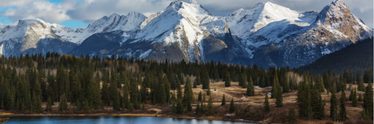 Snow-capped Colorado mountain range with rugged peaks and evergreen forests