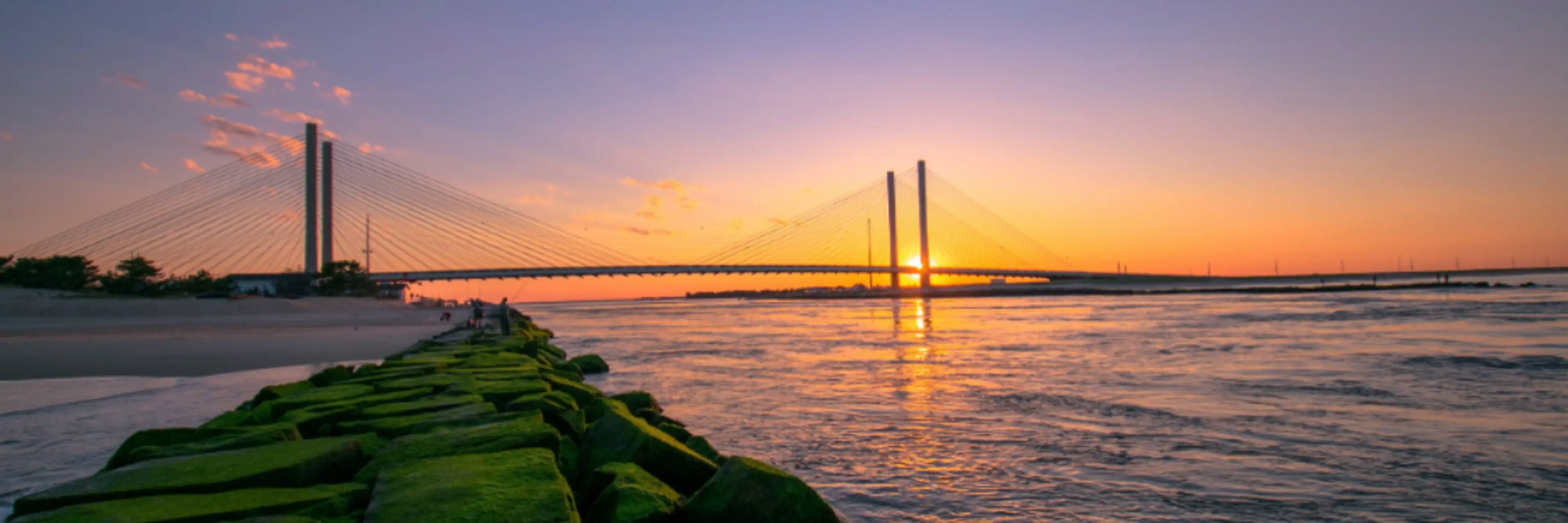 Delaware sunset over modern cable-stayed bridge reflecting on water