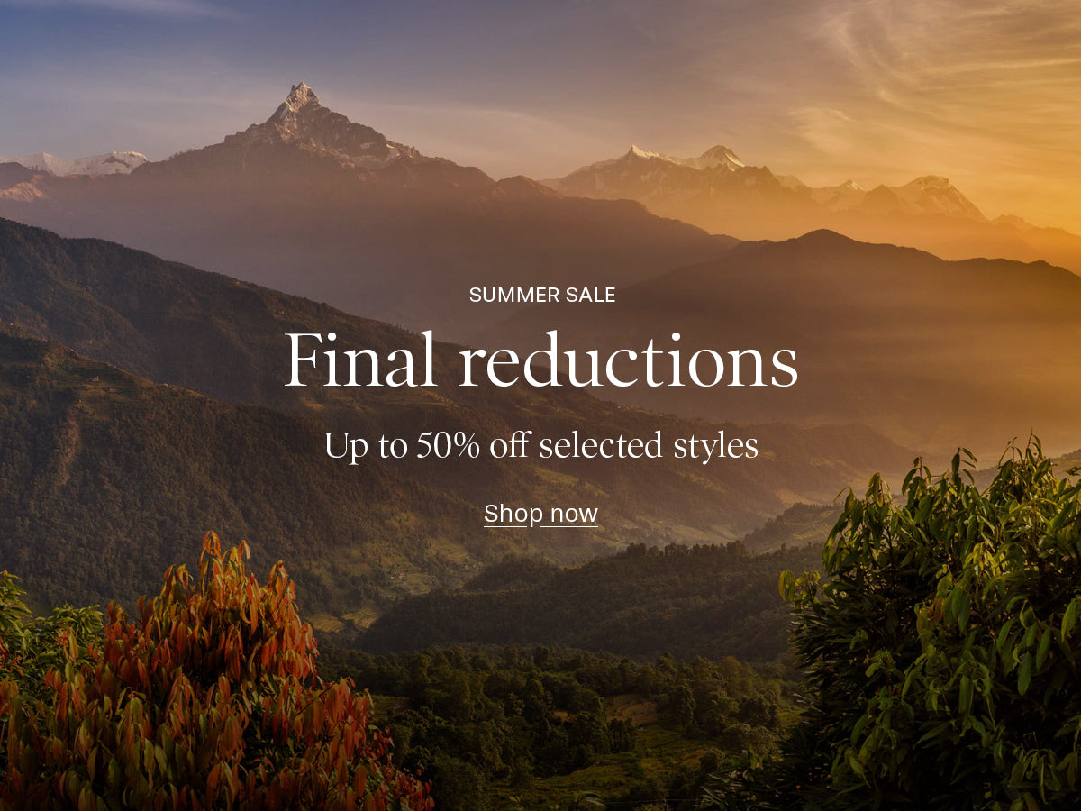 Mountain landscape promotional banner with layered peaks at sunset and overlaid sale text reading 'SUMMER SALE', 'Final reductions', 'Up to 50% off selected styles', and 'Shop now'.