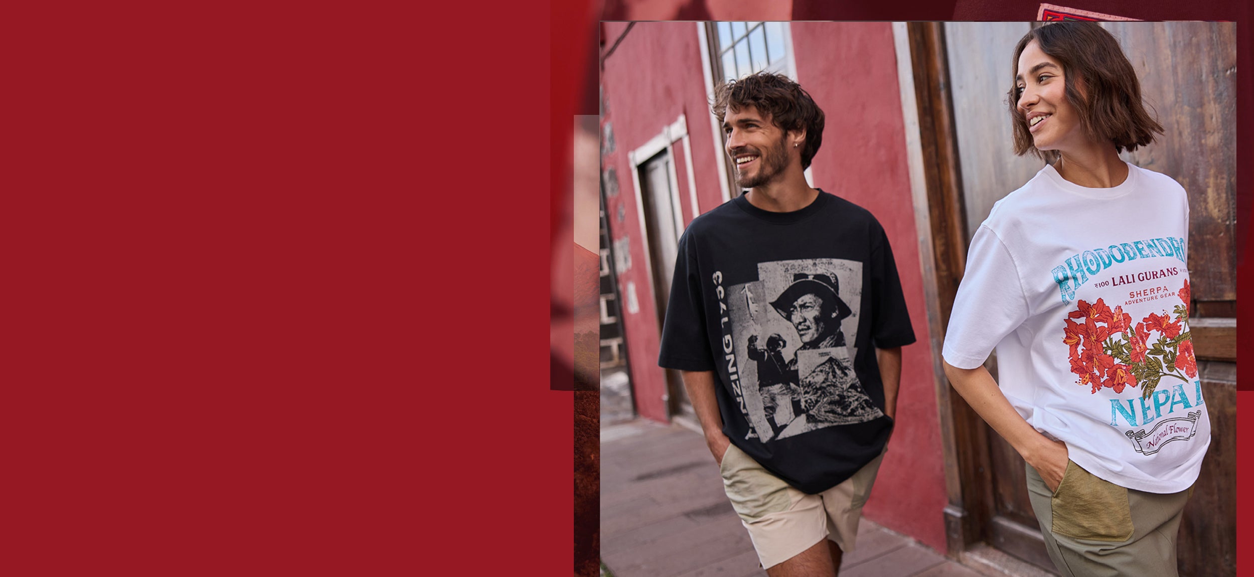 A man and a woman walking down a Spanish street. The man is wearing a black T-Shirt depicting Tenzing Norgay. The woman is wearing a white T-Shirt depicting a red rhododendron flower. They are smiling and have their hands in their pocket.