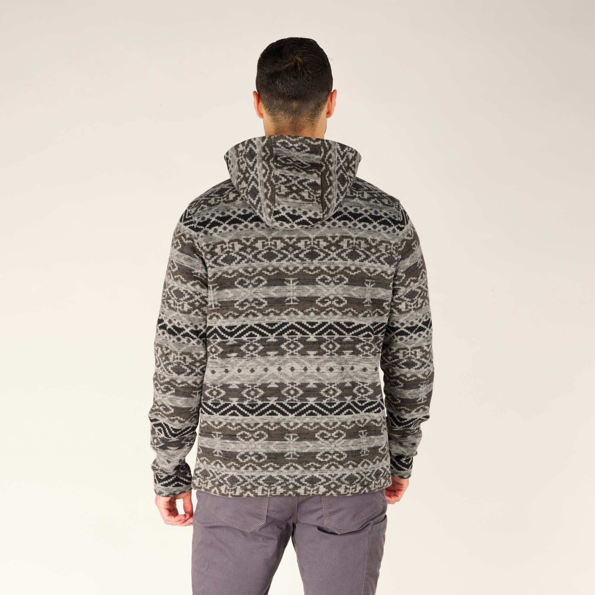The model is facing away from the camera, displaying the back of the Sherpa Adventure Gear Bhutan Full Zip Hoodie in Grey. The intricate Bhutanese pattern continues across the back and the hood, with a slightly rounded hemline.