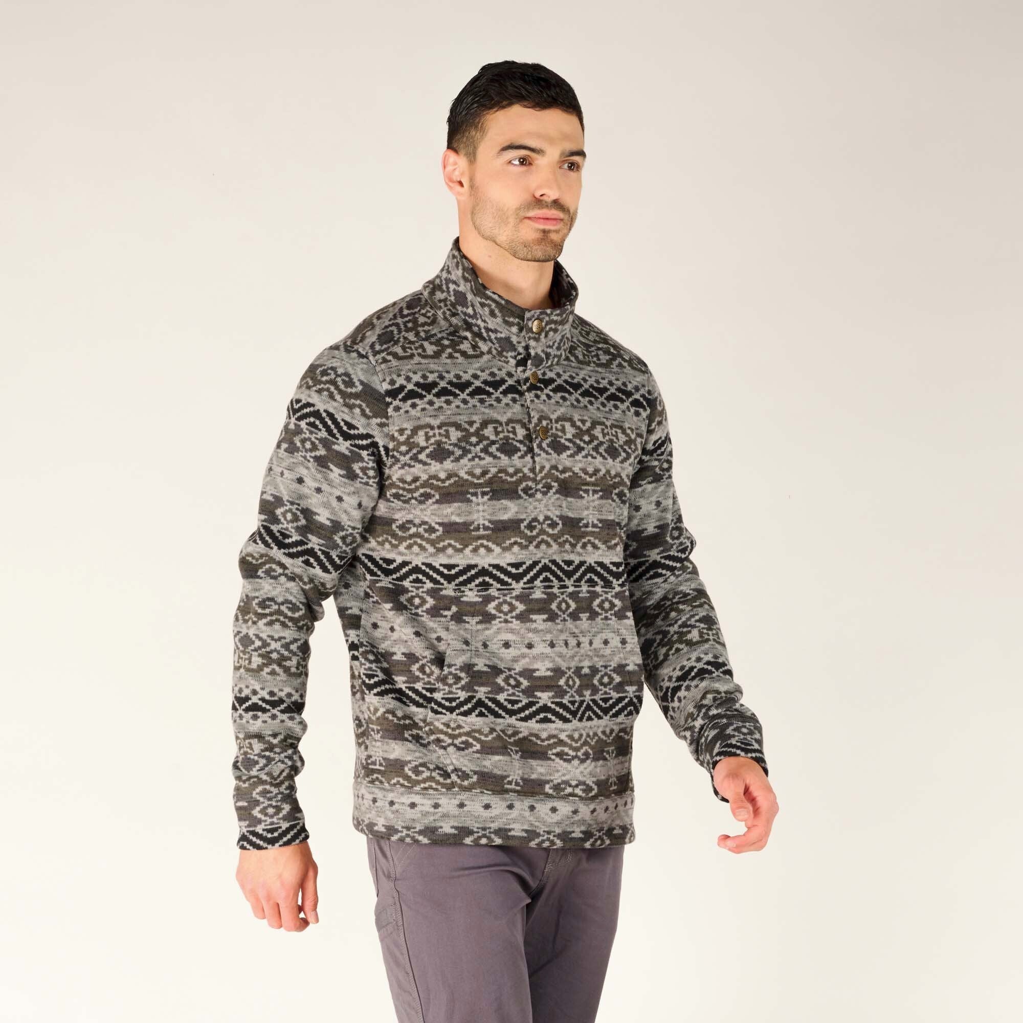 A side profile of the model wearing the Sherpa Adventure Gear Bhutan Pullover in Grey. The intricate patterns are visible on the sleeve, and the fit of the pullover emphasises comfort and versatility.