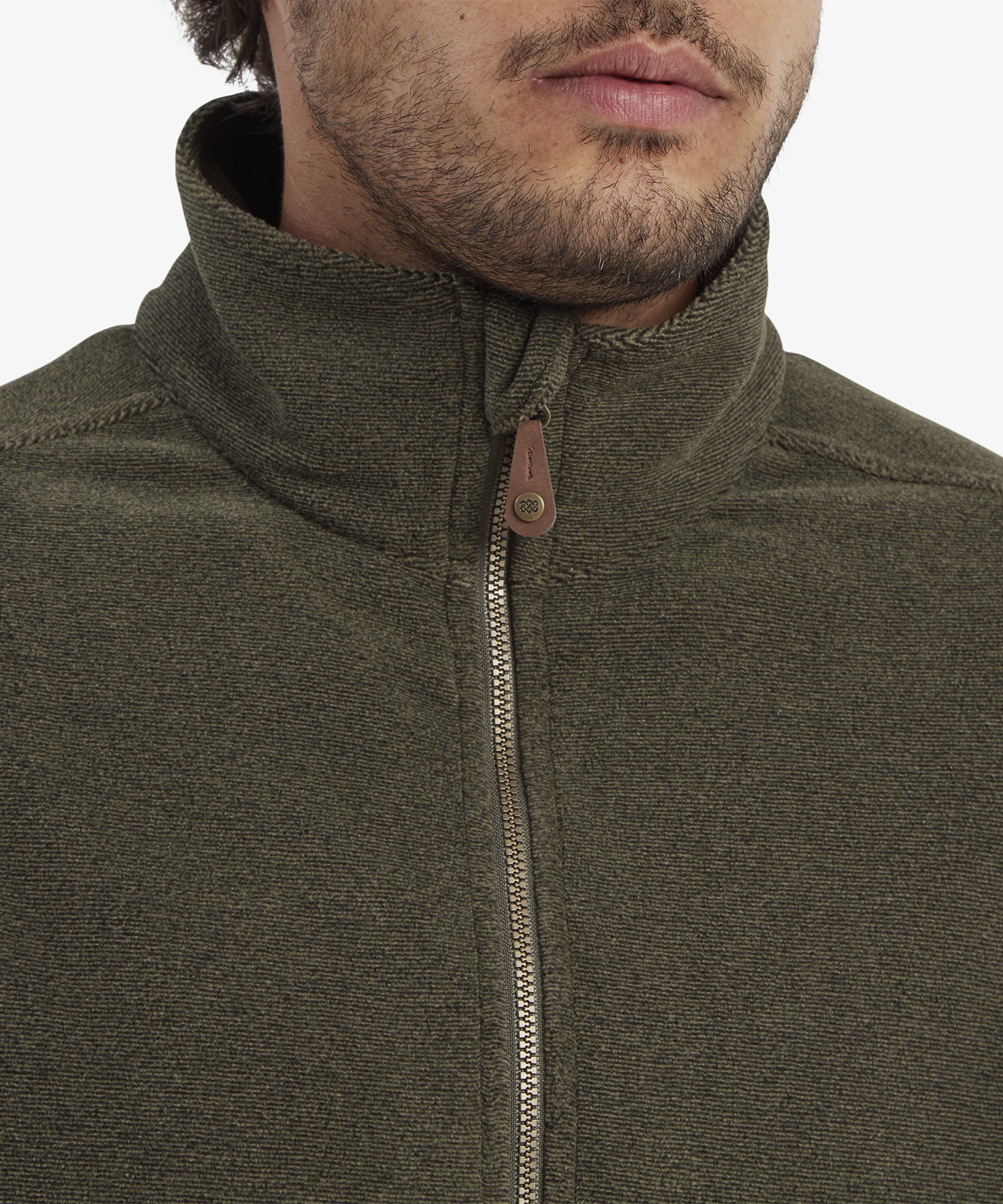 A detailed view of the Sherpa Adventure Gear Rolpa Eco Vest in Green's high collar and zipper. The metal zipper has a small leather pull tab with fine stitching, emphasising the craftsmanship of the garment.