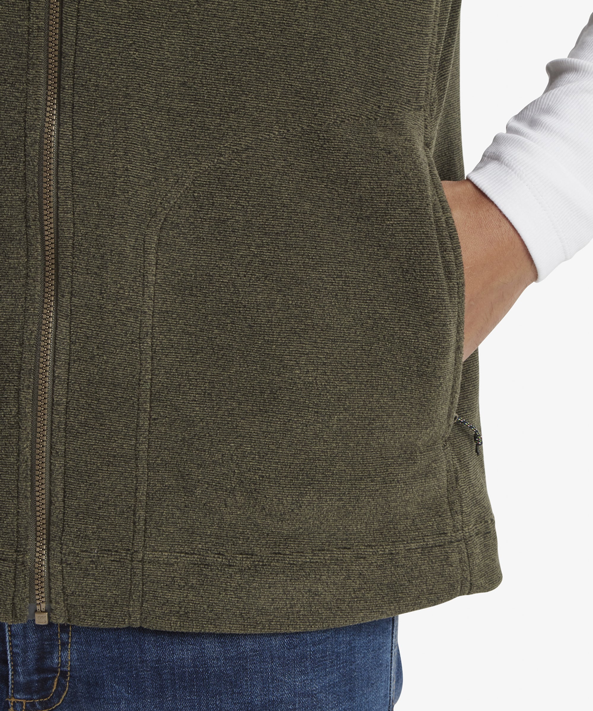A detailed shot of the side pocket on the Sherpa Adventure Gear Rolpa Eco Vest in Green, partially zipped. The stitching is clearly visible, and the pocket is functional, blending seamlessly into the design of the vest.