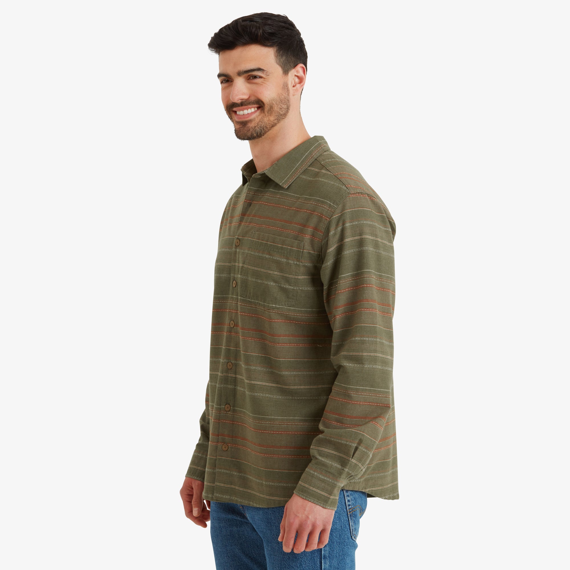 A side profile of the man wearing the Sherpa Adventure Gear Sangpo Long Sleeve Shirt in Grey. He is smiling while facing to the right, showcasing the shirt's relaxed fit and lightweight material.