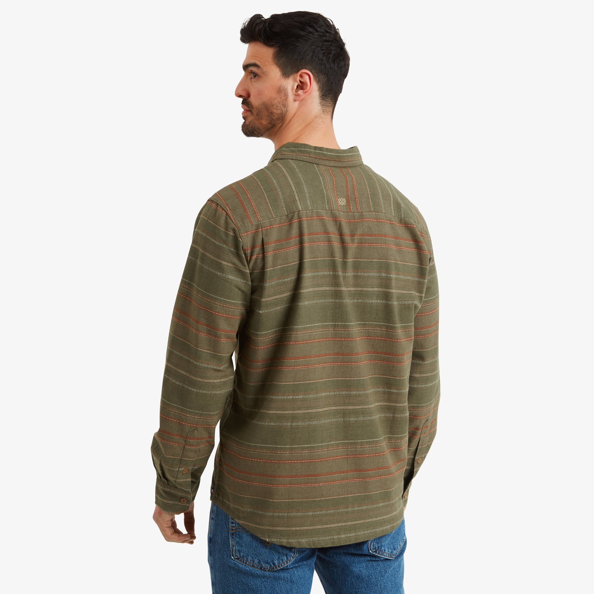 The back view of the model in the Sherpa Adventure Gear Sangpo Long Sleeve Shirt in Grey. The shirt features a simple back yoke and the horizontal stripes continue across the back. The model pairs the shirt with light blue denim jeans.