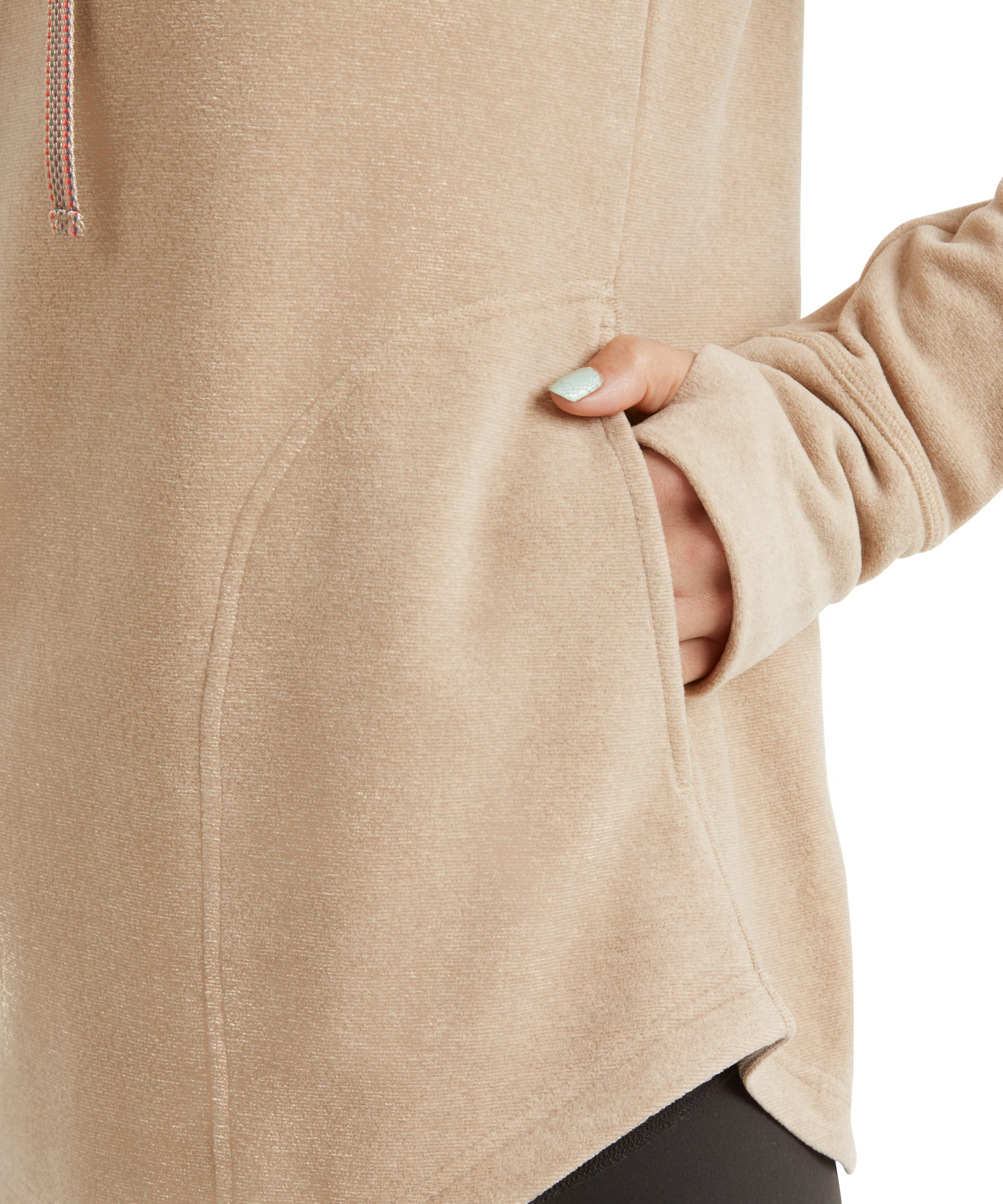 A close-up of the hand warmer pockets, with one hand casually placed inside, highlighting the practical yet stylish design. The Sherpa Adventure Gear Rolpa Eco Pullover in Beige fabric texture is clearly visible, enhancing the warm and cozy appeal.