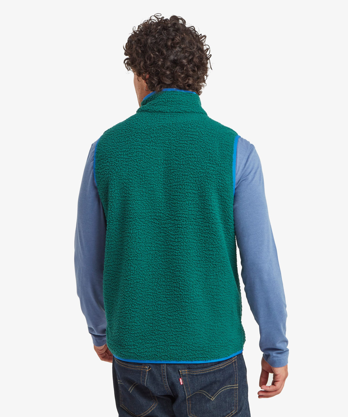 A man viewed from the back wearing a green fleece vest over a light blue long-sleeve shirt.