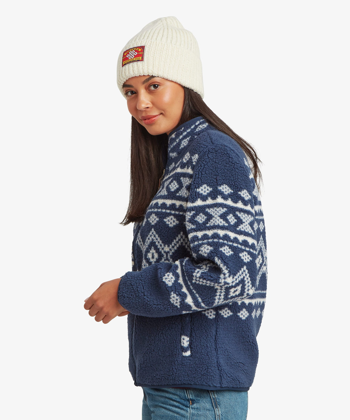 Side profile of a woman wearing a blue fleece zip jacket with white Fair Isle-inspired patterning.