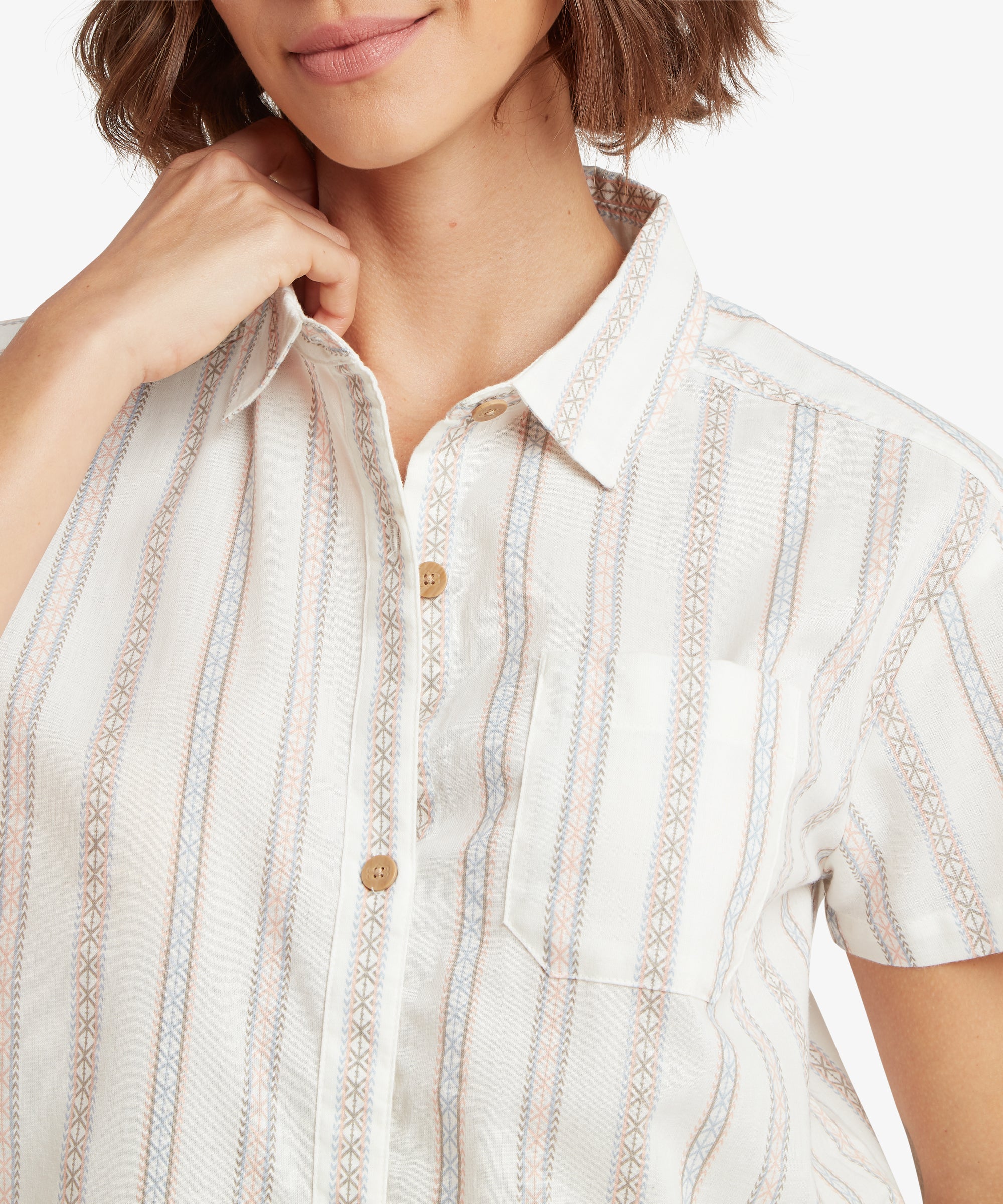 A close-up detail shot of the shirt’s neckline and chest, showcasing the intricate geometric motifs within the vertical stripes. The image highlights the soft texture of the woven fabric, the matching chest pocket, and the small, wood-like buttons that secure the front closure.