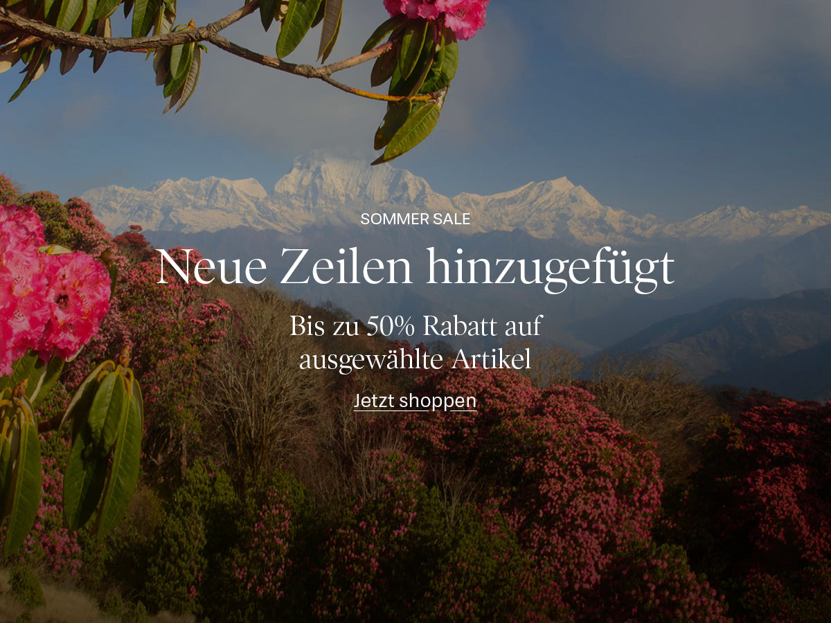 A promotional banner featuring a scenic mountain landscape with snow-capped peaks, pink rhododendron flowers in the foreground, and German text overlay reading 'SOMMER SALE', 'Neue Zeilen hinzugefügt', 'Bis zu 50% Rabatt auf ausgewählte Artikel', and 'Jetzt shoppen'.