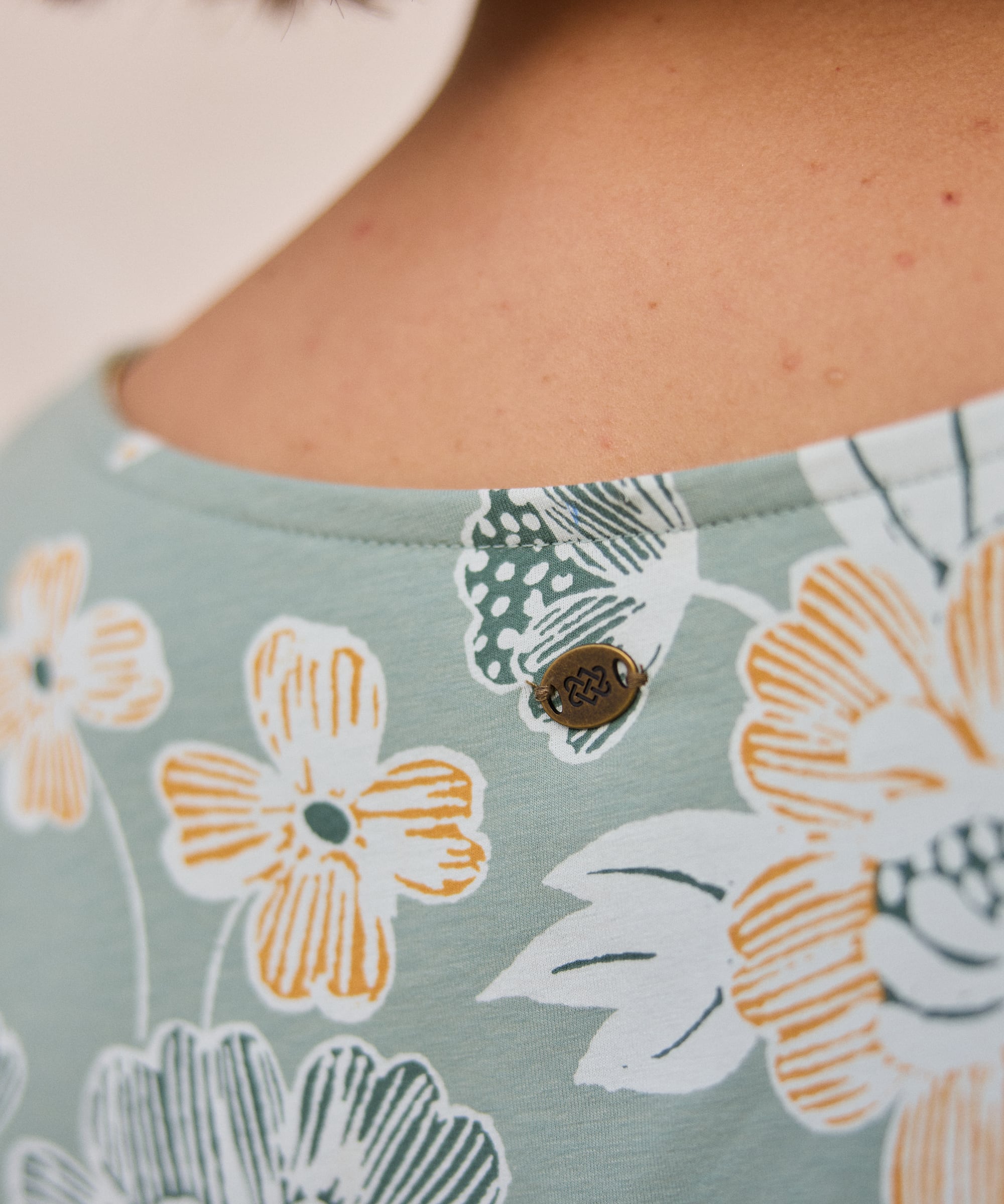 Neha T-Shirt Celery Floral with bronze engraved button on green top