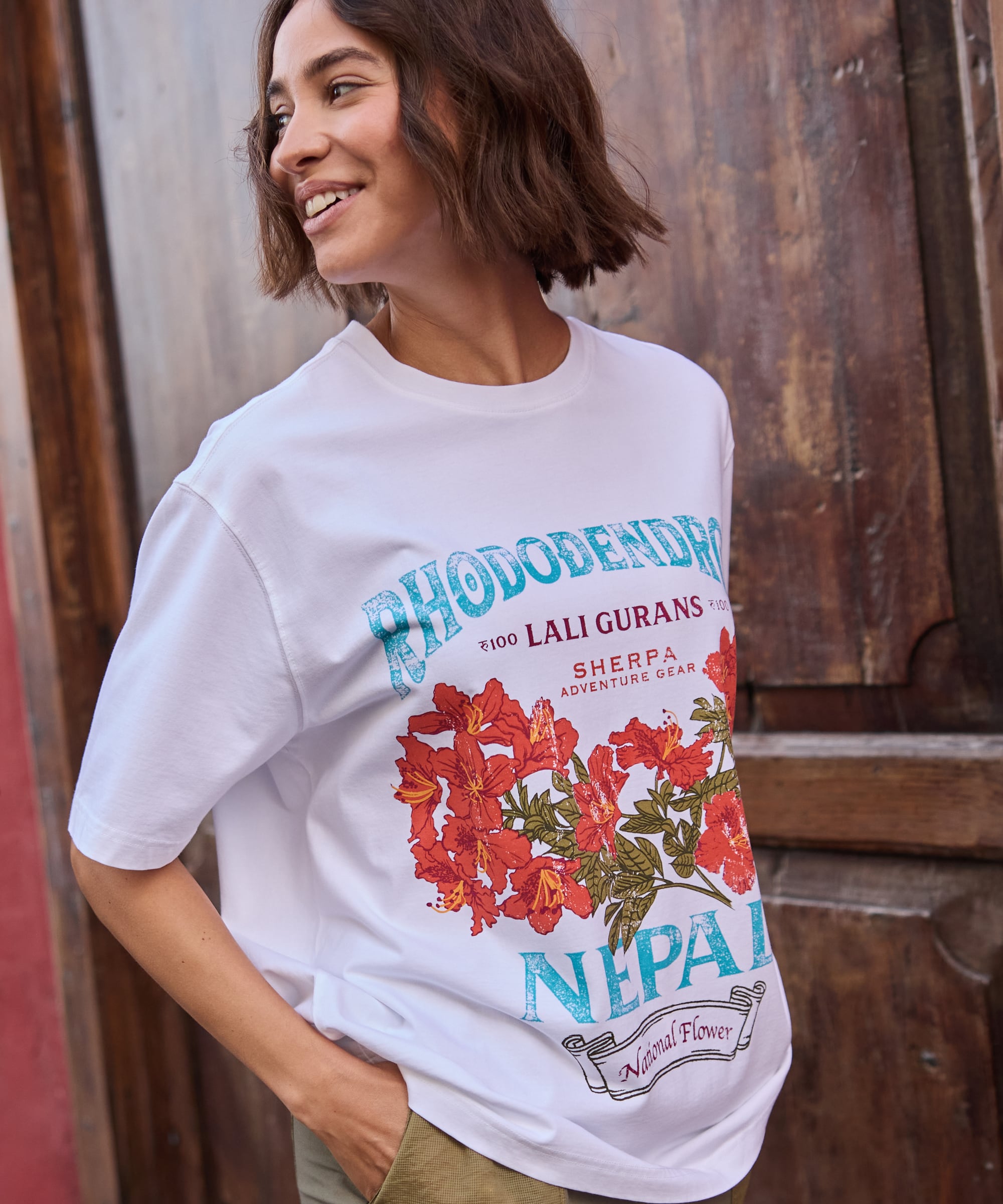 Tarcho Rhododendron T-Shirt Ð Katha White mit rotem Blumenmuster und tŸrkisfarbenem Text