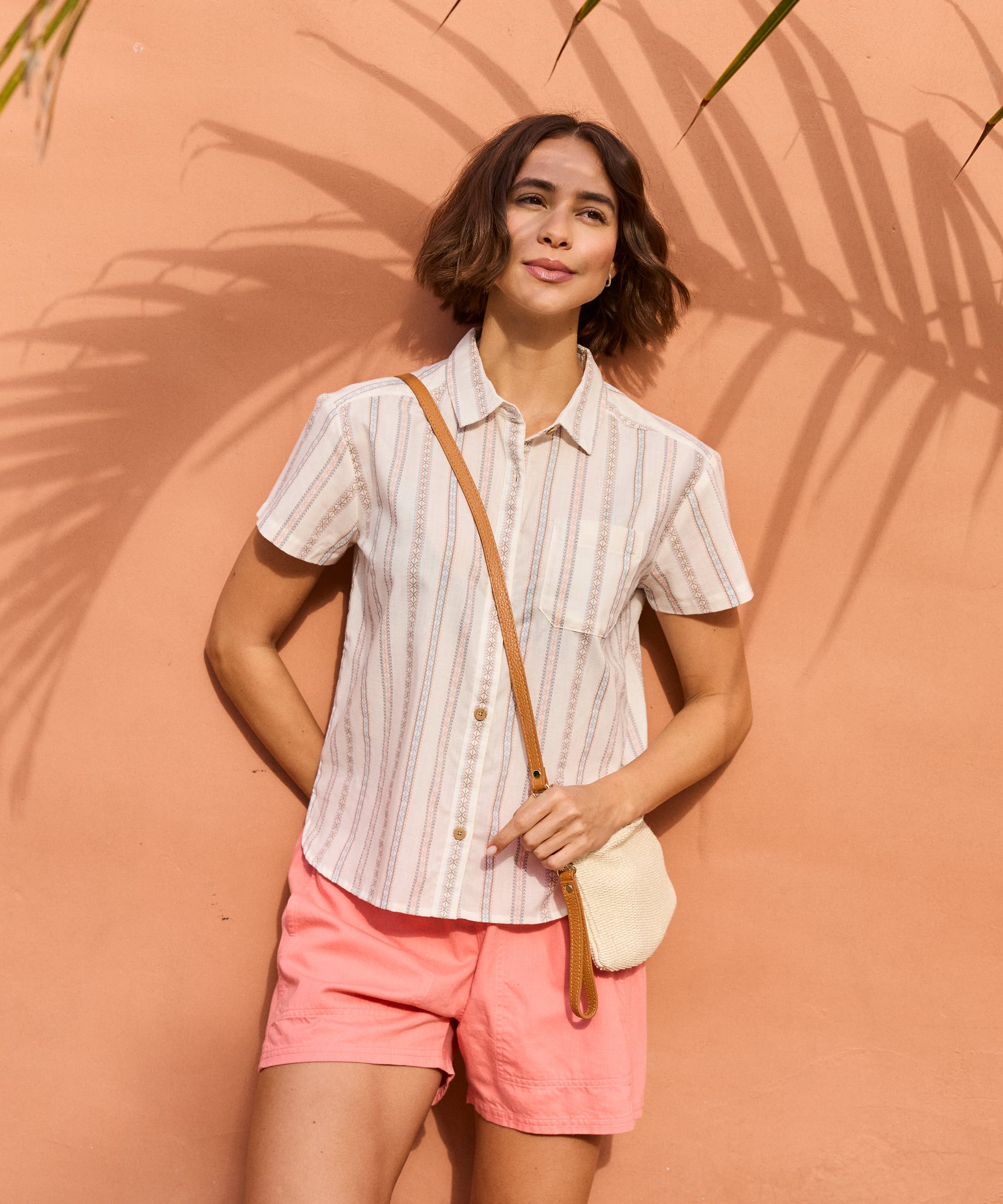 Woman in Palmo Shorts Rose Gold wearing striped button-up shirt