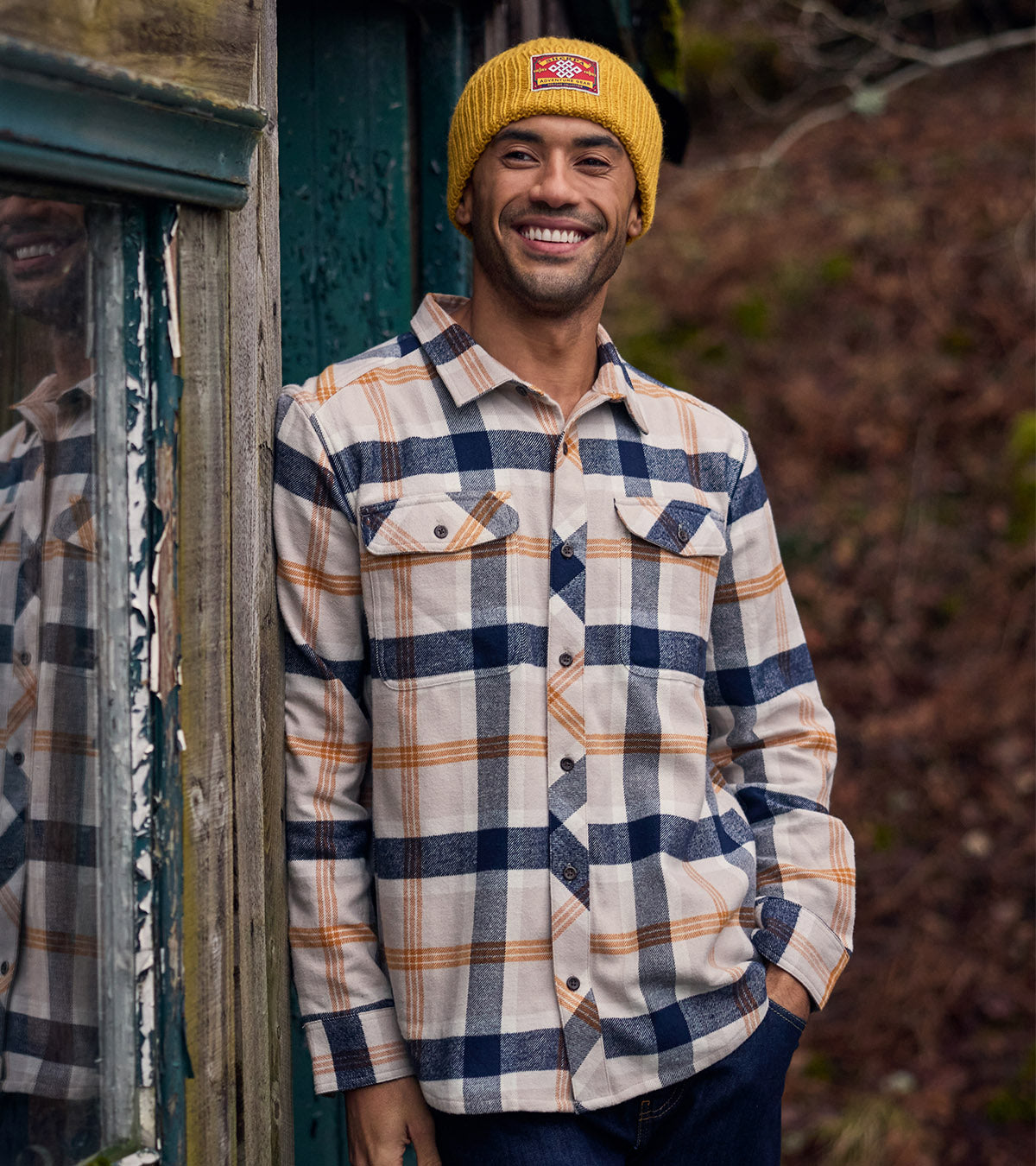 A smiling man wearing a yellow beanie.