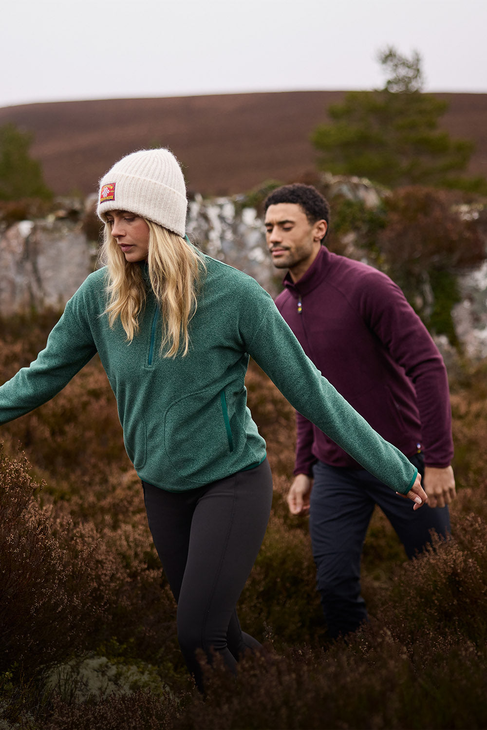 Woman in green fleece quarter-zip walking through Scottish moorland