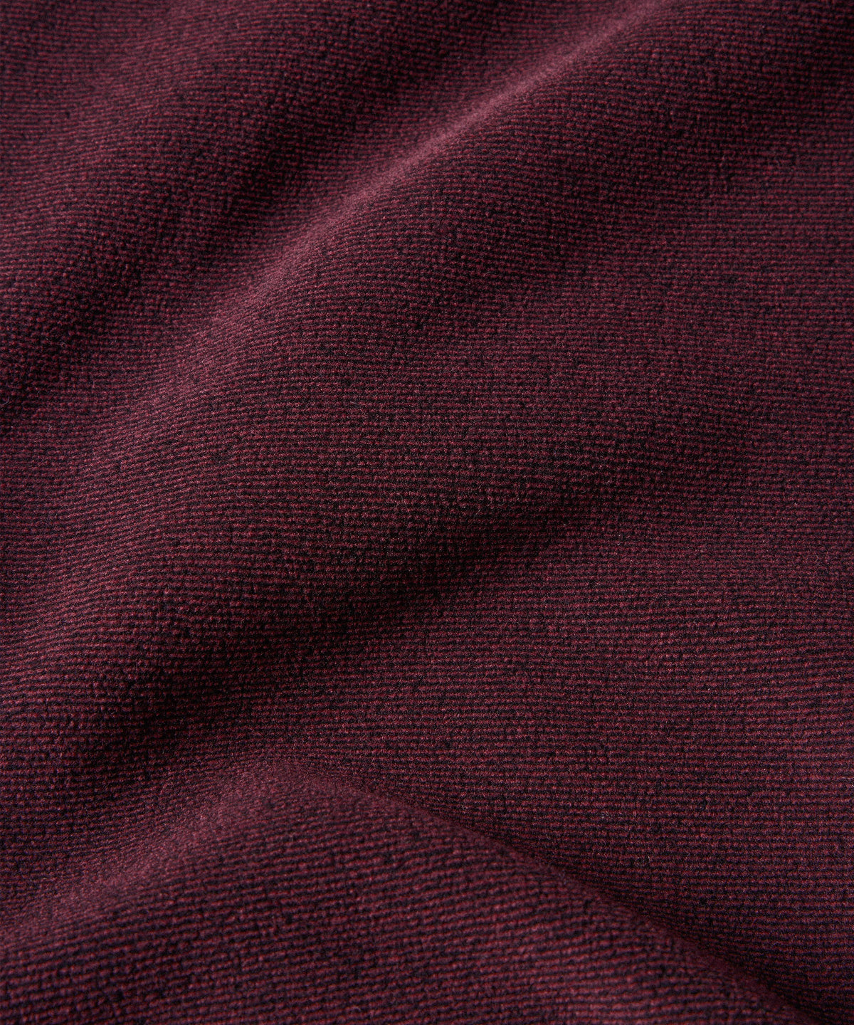 A close up image of a merlot colored fleece fabric.