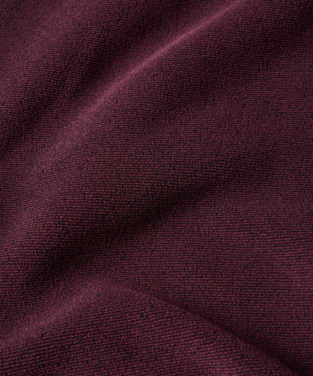 A close-up of textured fleece fabric in a purple showing the fine ribbed weave.