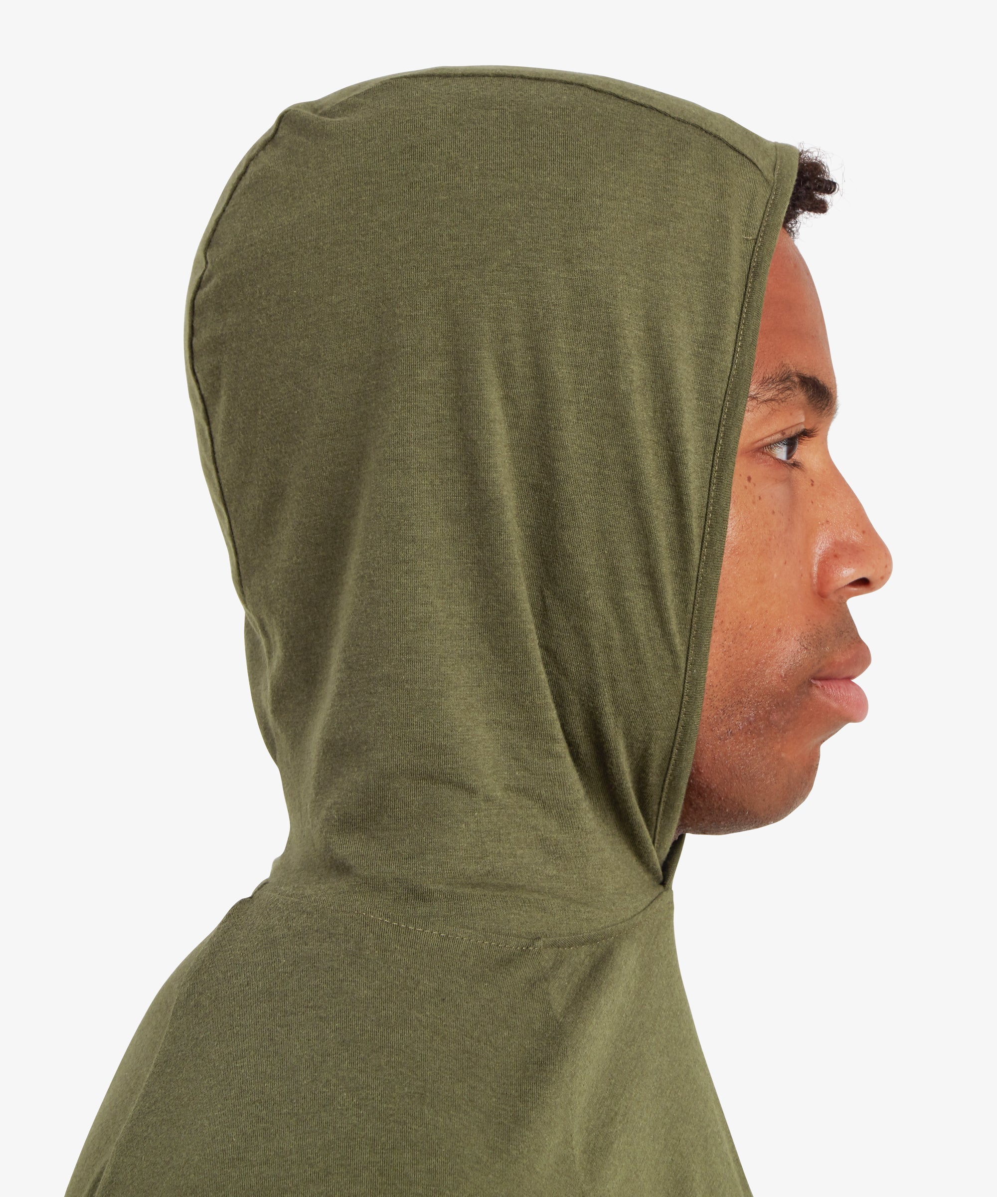 A close up, side view of a man's head and shoulders. The man us wearing a green hoodie with the hoodie up over his head. The man is looking to his left.