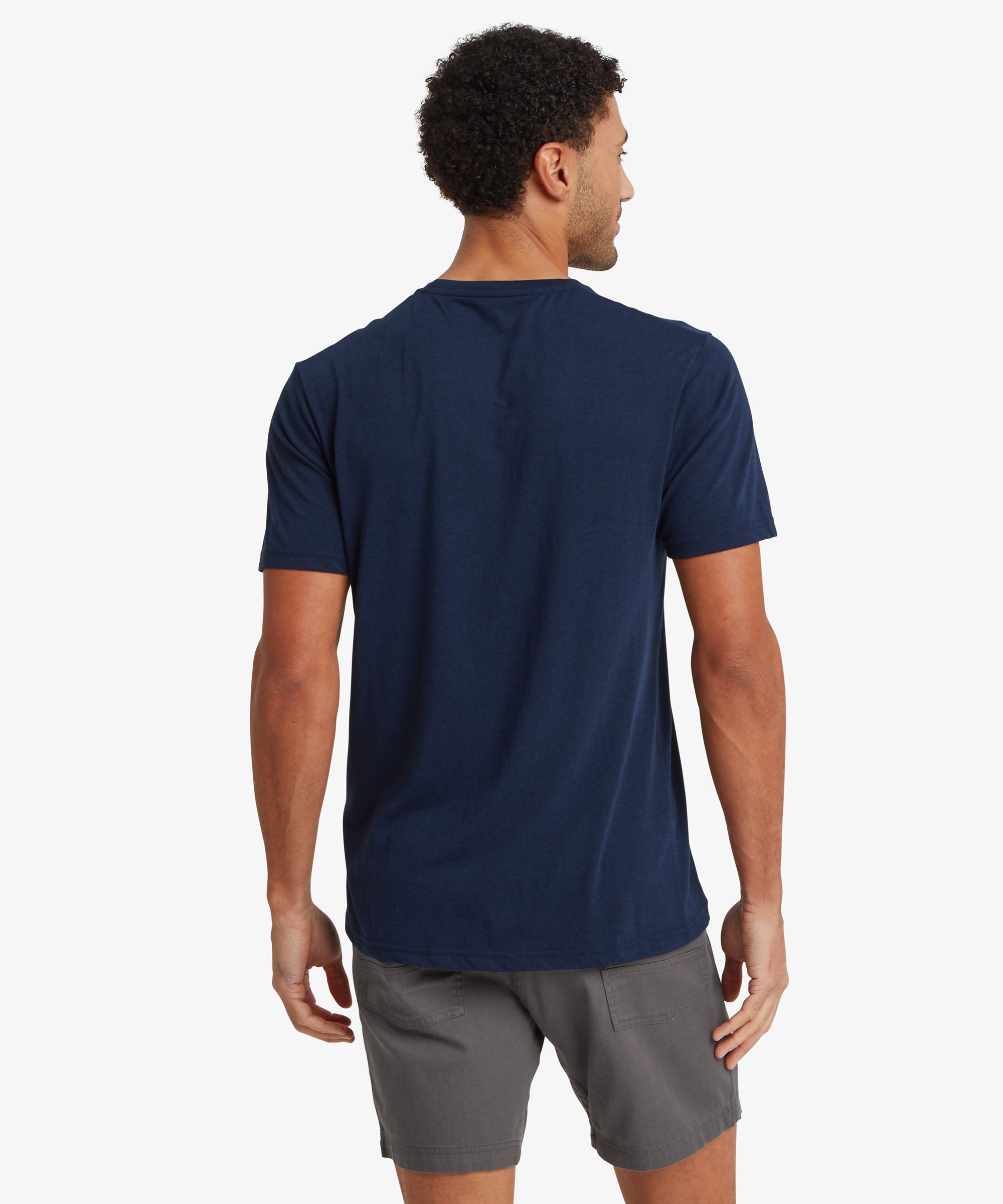 Rear view of a person wearing a navy T‑shirt and grey shorts.