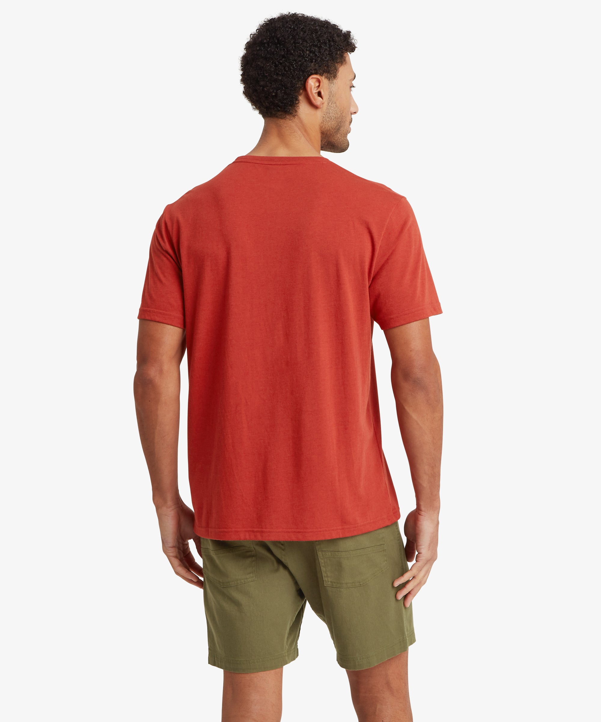 Man wearing a red t-shirt and green shorts on a white background