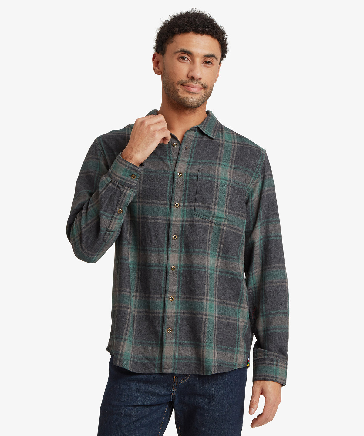A man wearing a long-sleeve button-up flannel shirt with a green.