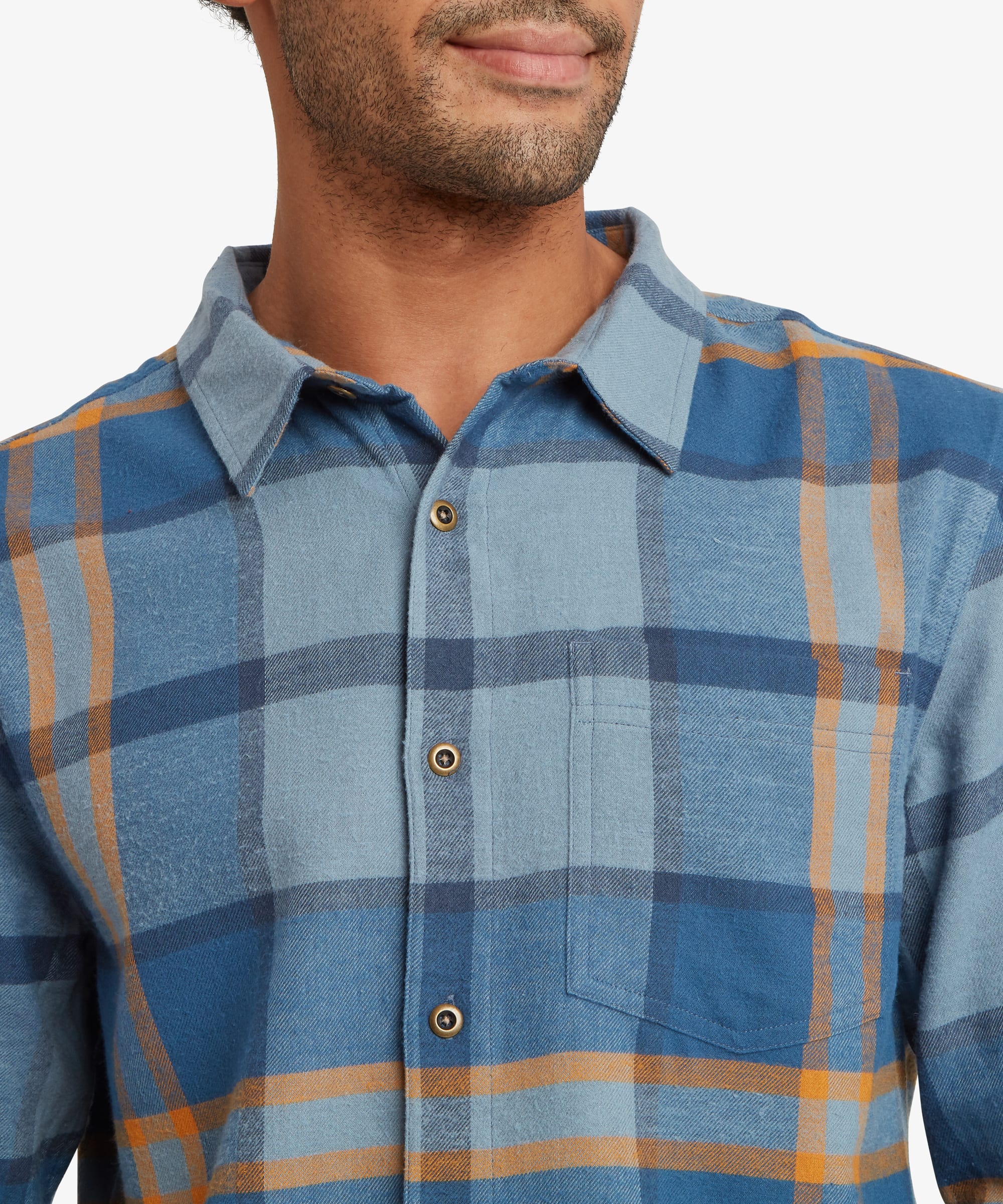 Close-up of a blue plaid long-sleeve shirt showing the classic collar, button-front placket and woven check pattern in shades of blue, grey and mustard. Natural-look buttons add a casual finish.
