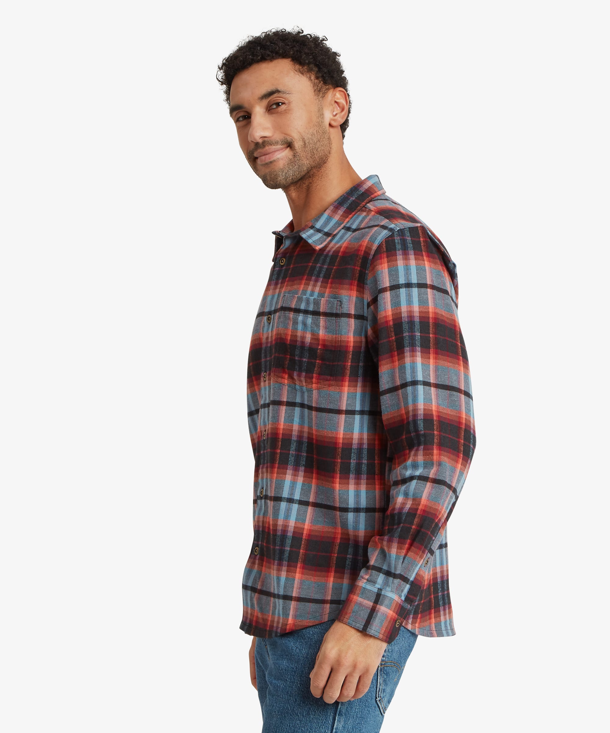 Side view of a man wearing a red plaid long-sleeve shirt showing the drape of the fabric, curved hem and comfortable fit through the torso and sleeves.