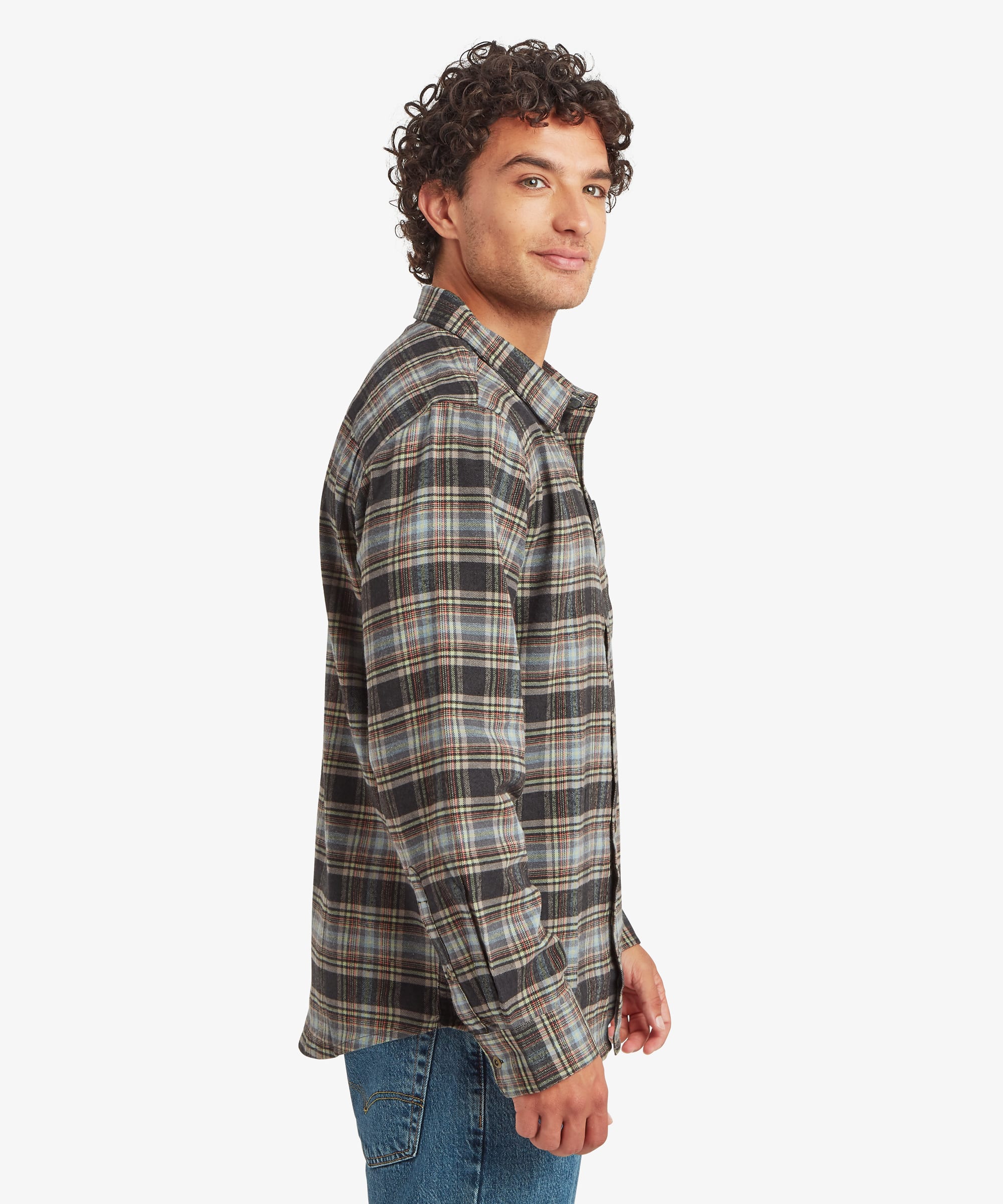 Side profile of a man wearing a long-sleeve plaid shirt featuring olive green, brown, cream and charcoal checks. The regular-fit shirt falls below the hips and features a button-front placket, chest pocket and button cuffs.
