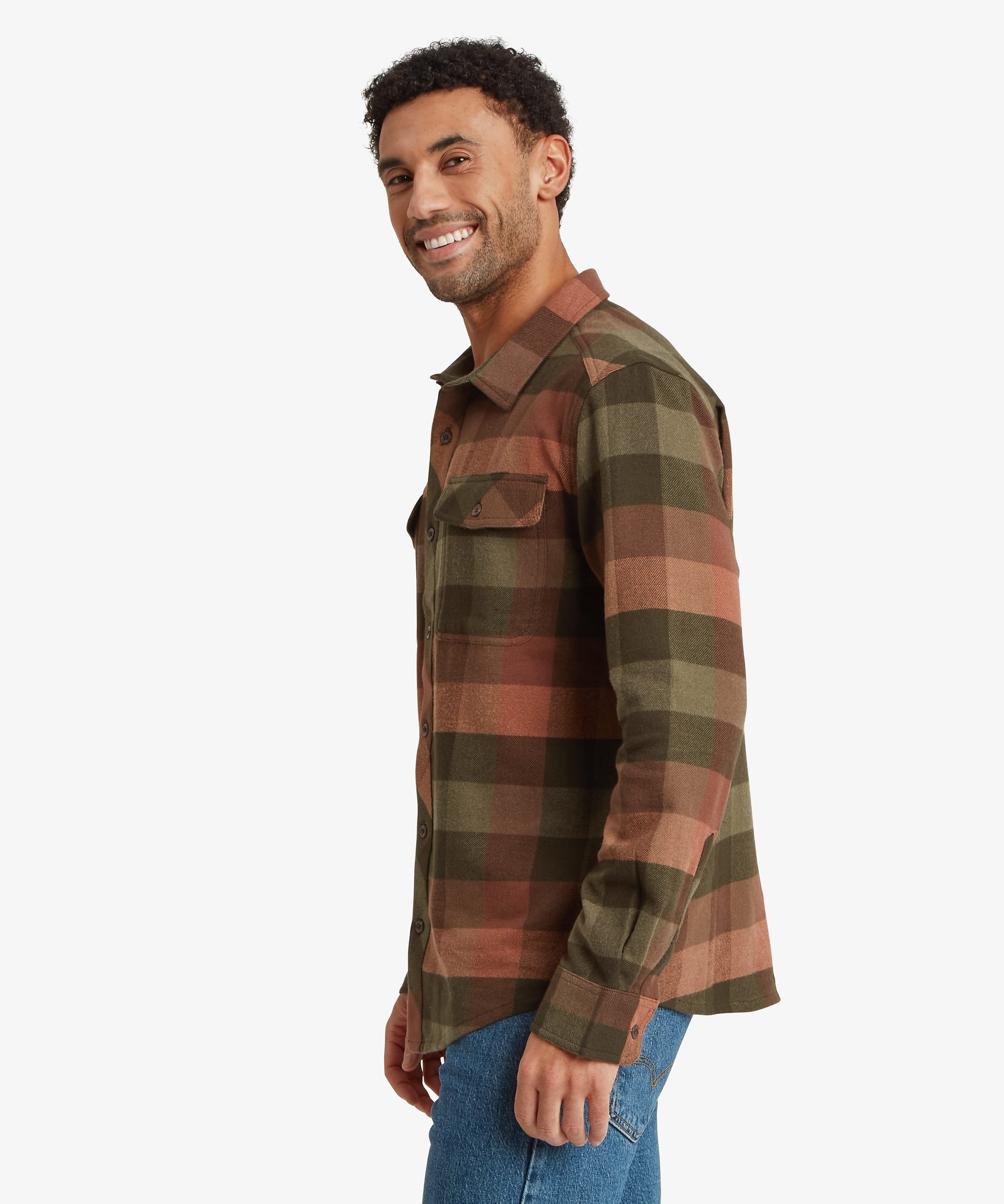 Side profile of a plaid overshirt in olive green, rust brown and charcoal tones. The relaxed-fit silhouette is designed for layering and features long sleeves, button cuffs and a spread collar.