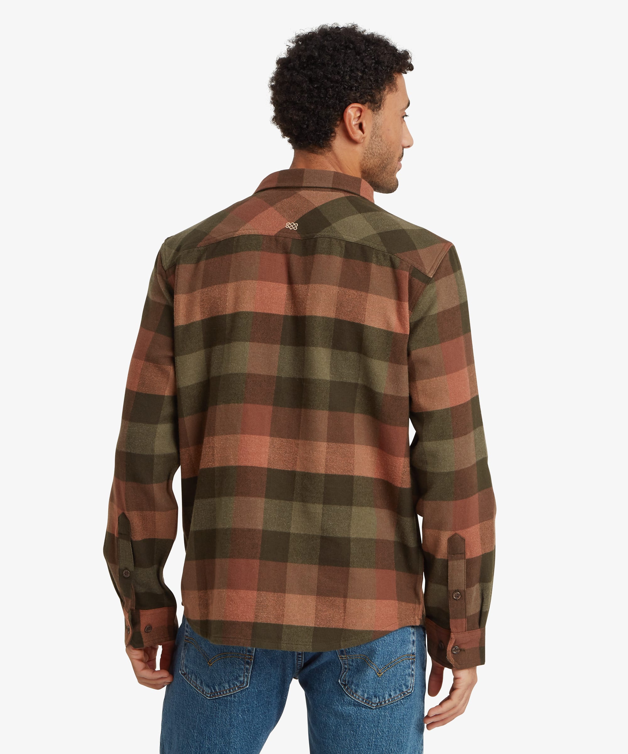 Back view of an olive green plaid overshirt showing the back yoke seam, long sleeves and relaxed fit through the shoulders and body. The plaid pattern combines earthy green, rust and charcoal tones.