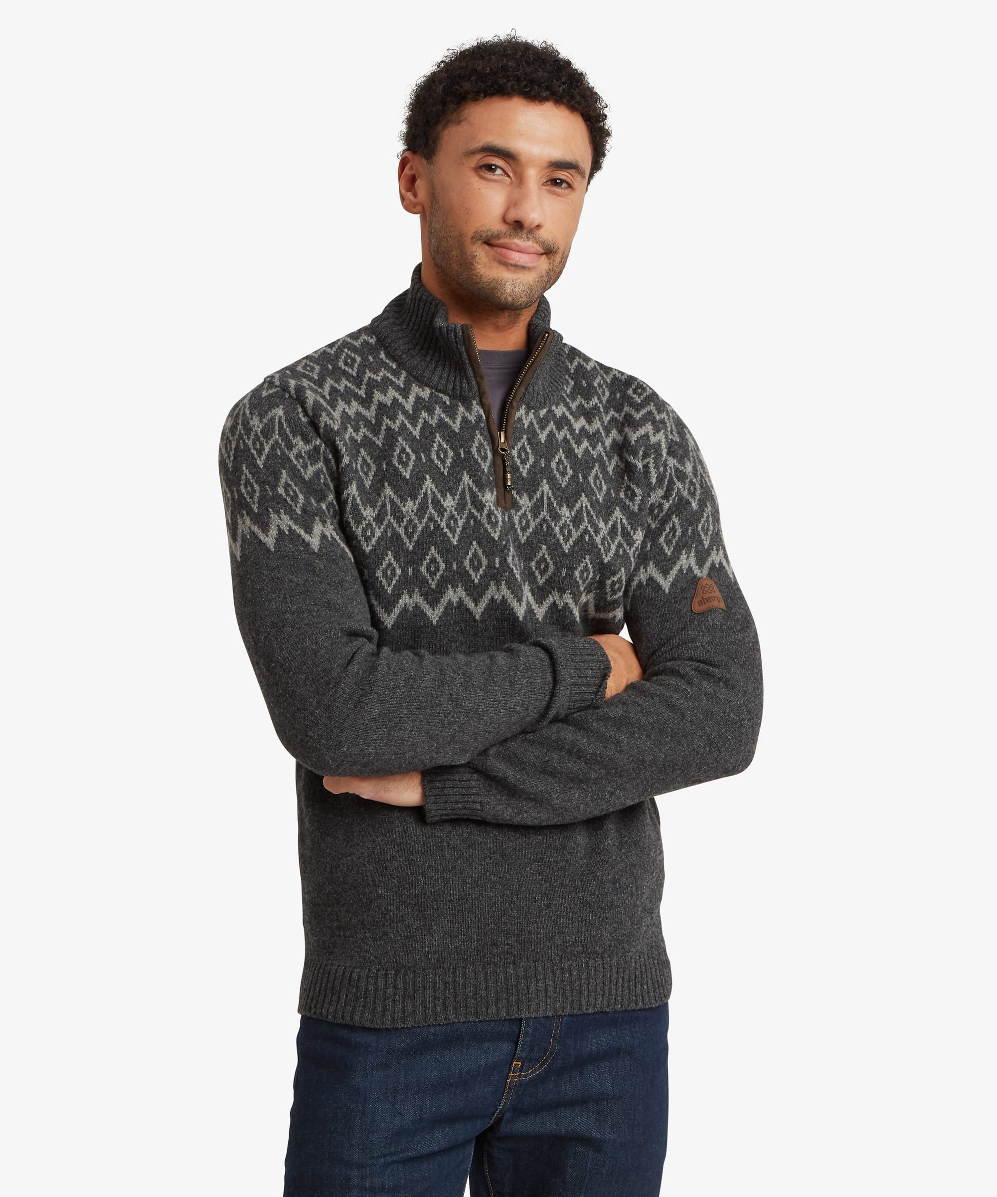 Front view of a man wearing a charcoal grey quarter-zip sweater with a regular fit. The sweater features a high stand collar with a contrast zip opening and a Fair Isle-inspired geometric knit pattern in grey and cream across the chest and shoulders. The man stands with arms crossed.