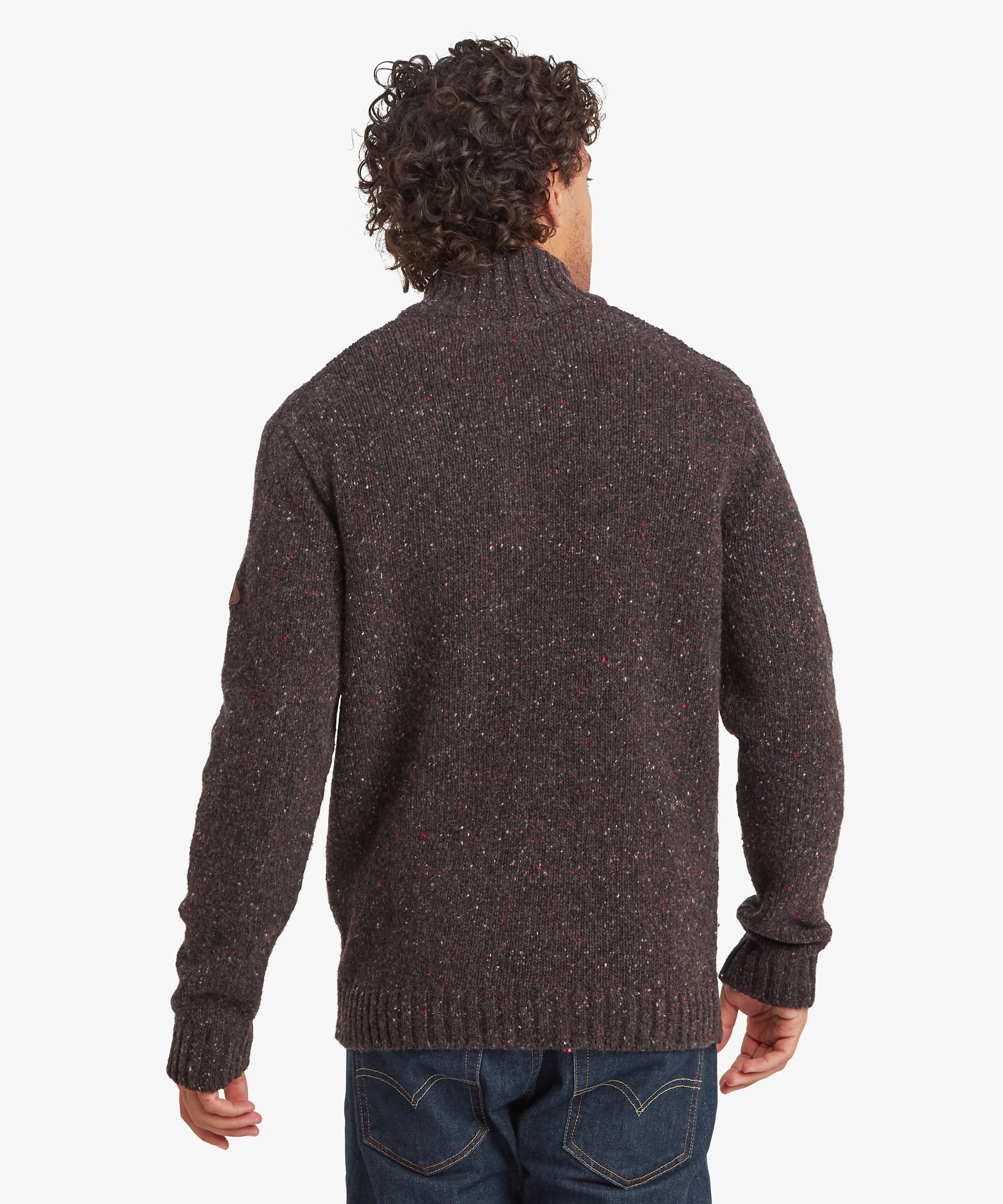 Rear view of a man wearing a charcoal black quarter-zip sweater. The regular-fit design features a high ribbed collar and plain knit back, with the patterned yoke visible wrapping around the shoulders. Styled with blue jeans.