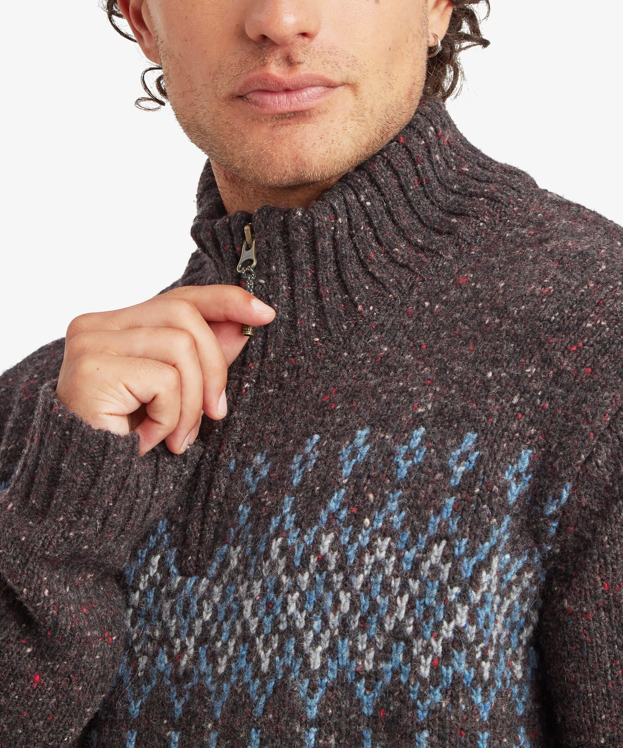 Close-up of the charcoal black quarter-zip sweater showing the ribbed stand collar, contrasting zip placket and geometric knit pattern in blue, grey and cream. The textured knit construction and collar details are clearly visible.