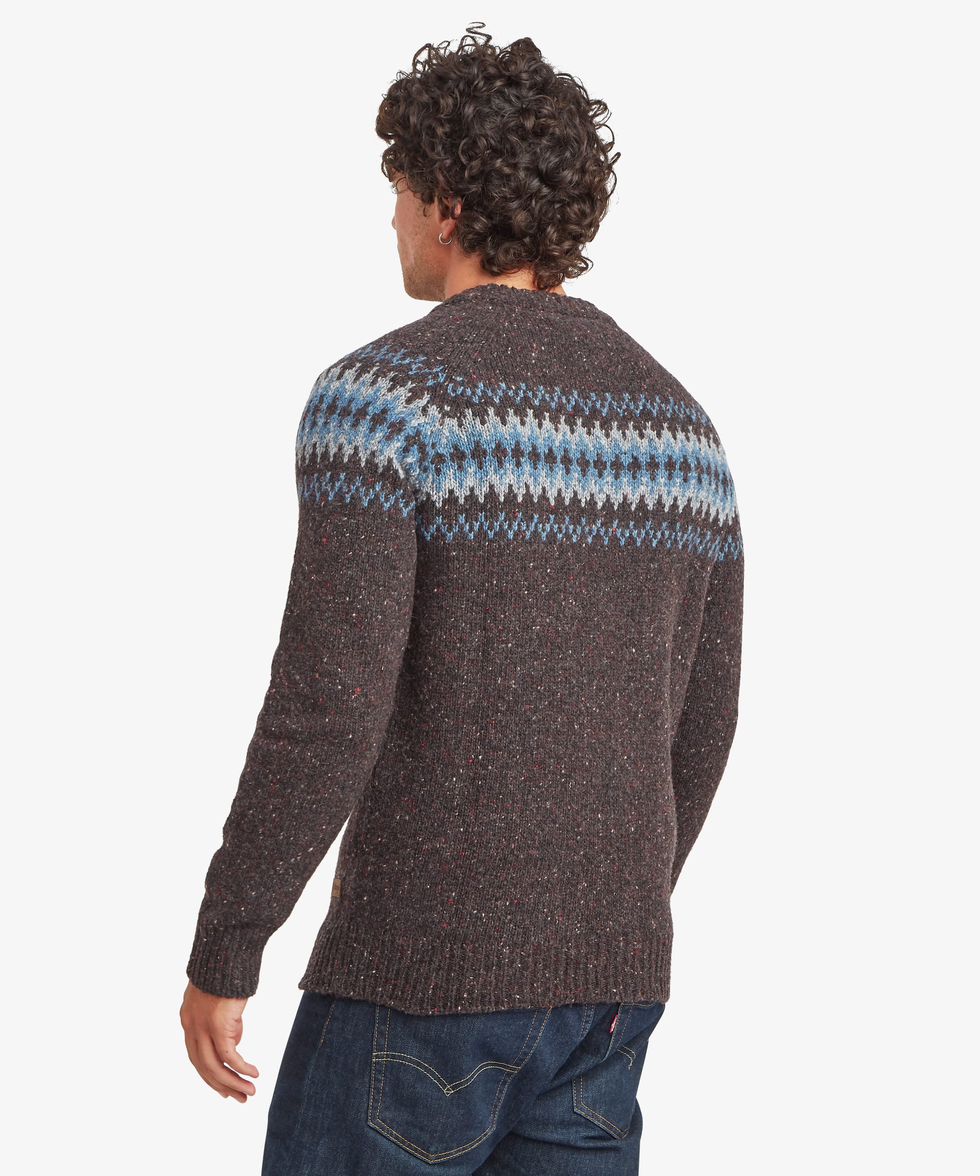 Rear view of a charcoal black crew neck sweater showing the geometric knit pattern extending across the shoulders and upper back. The regular-fit design is styled with blue jeans and finished with ribbed trims.