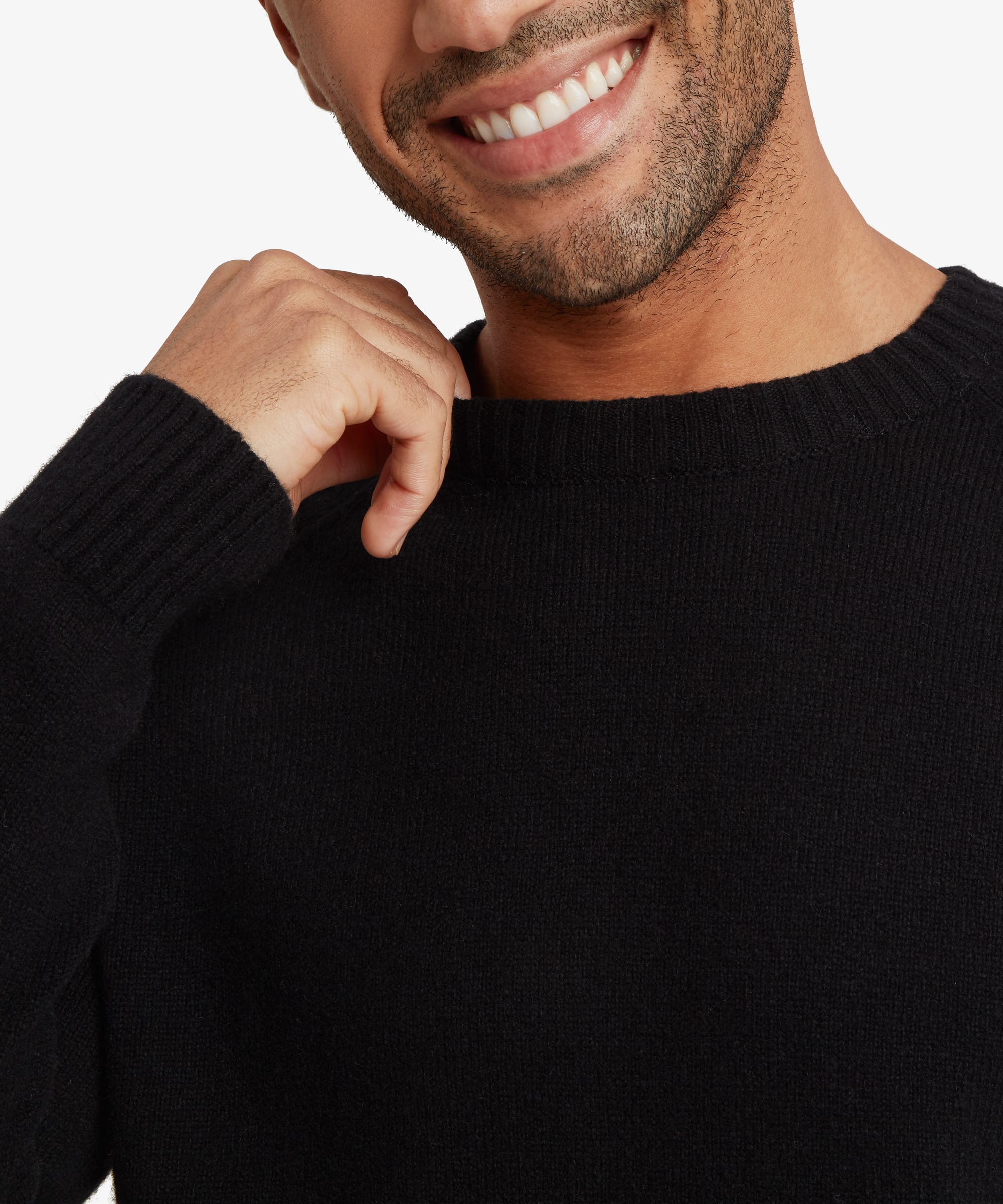 Close-up of the upper body showing a male model wearing the Sherpa Kangtega Crew Sweater in black, highlighting the finely knitted texture, classic crew neckline, ribbed collar and raglan sleeve construction.