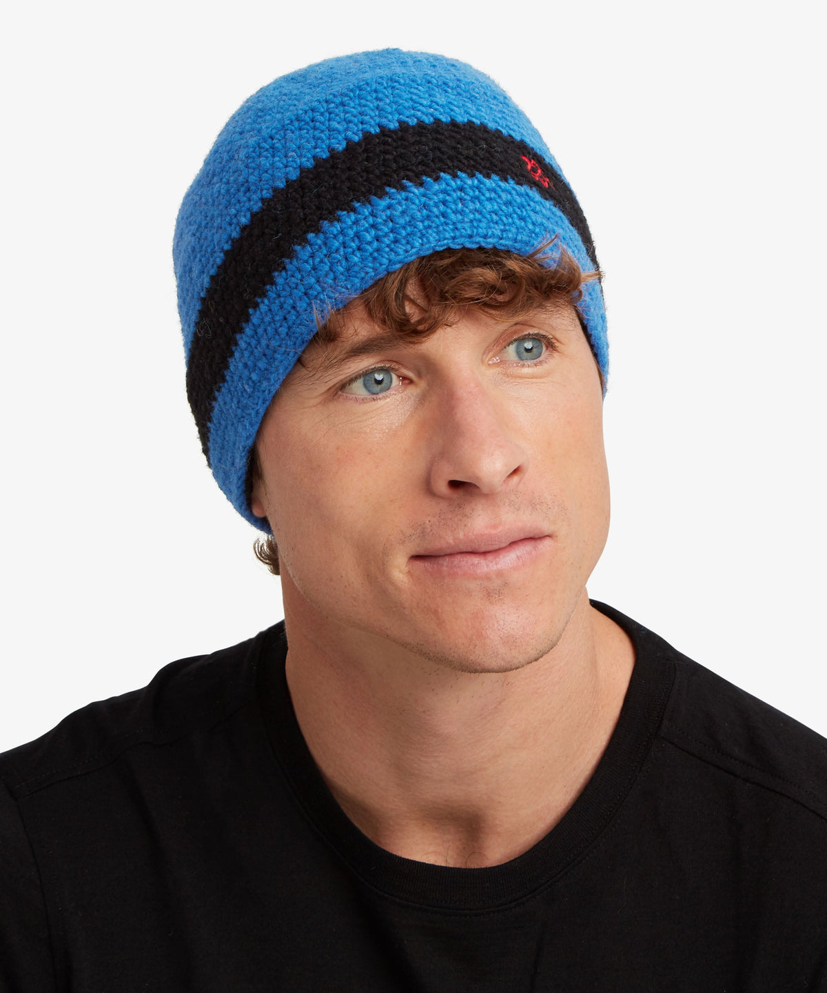 A man wearing a bright blue knit beanie with a thick black horizontal stripe.
