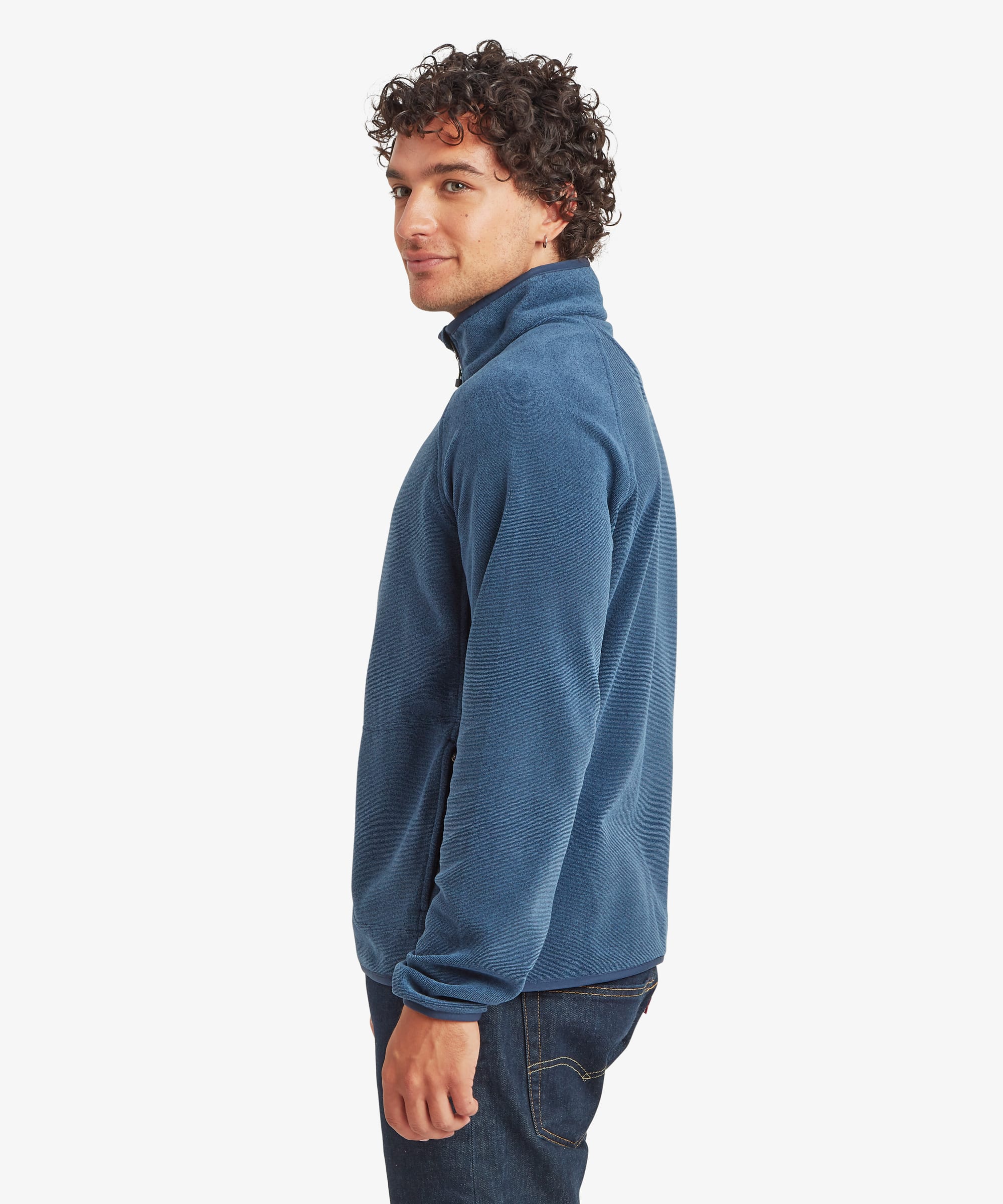 Side profile of a man wearing a heathered blue quarter-zip fleece pullover. The regular-fit layer features a stand collar, raglan sleeves and a zippered chest pocket. Styled with dark trousers, the fleece offers a comfortable fit through the body and sleeves.