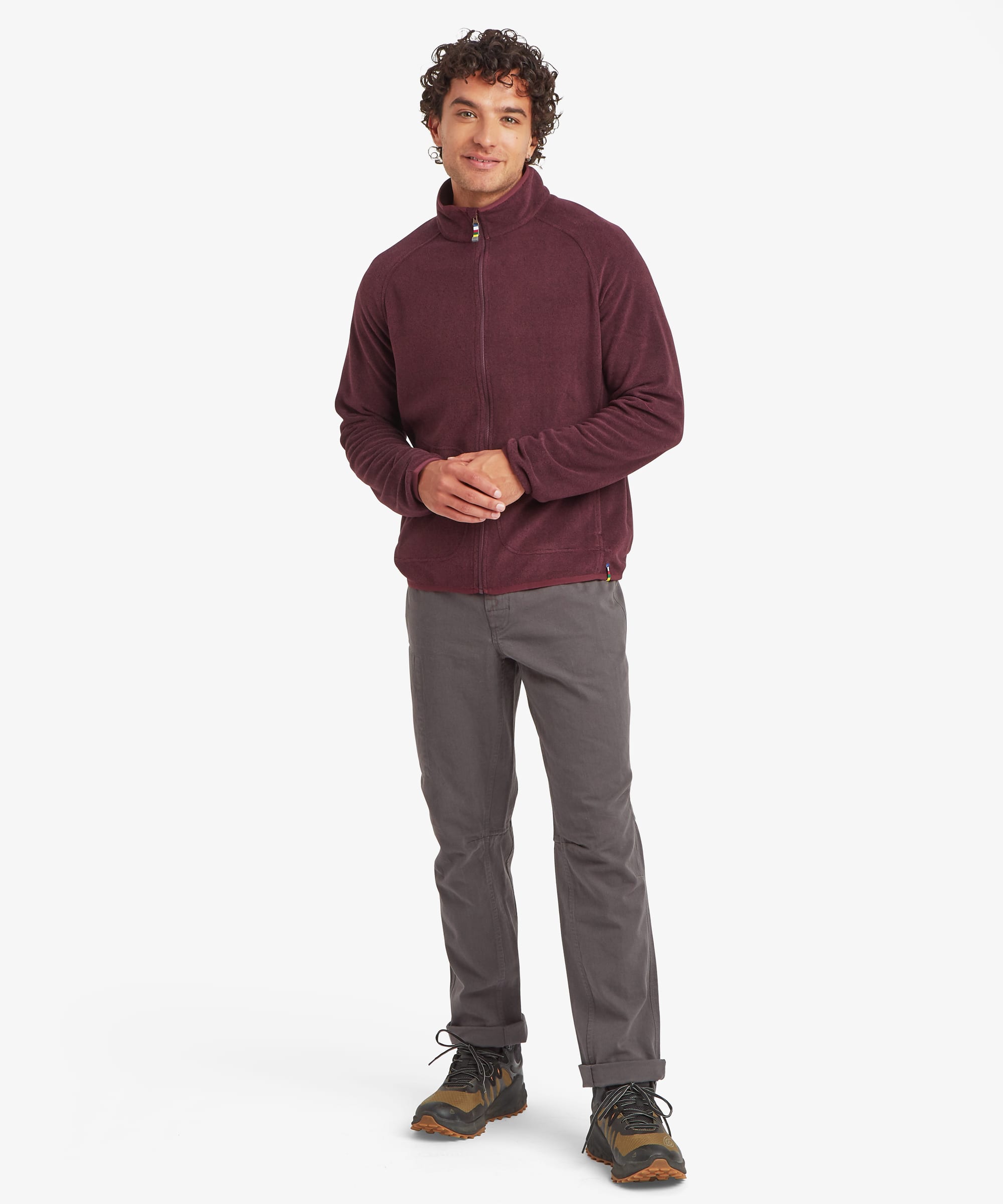 Full-body front view of a man wearing a burgundy Rolpa full-zip fleece jacket. The jacket has a high collar, full-length zipper, zip hand pockets, and a comfortable outdoor-ready fit. Styled with grey pants and hiking shoes.