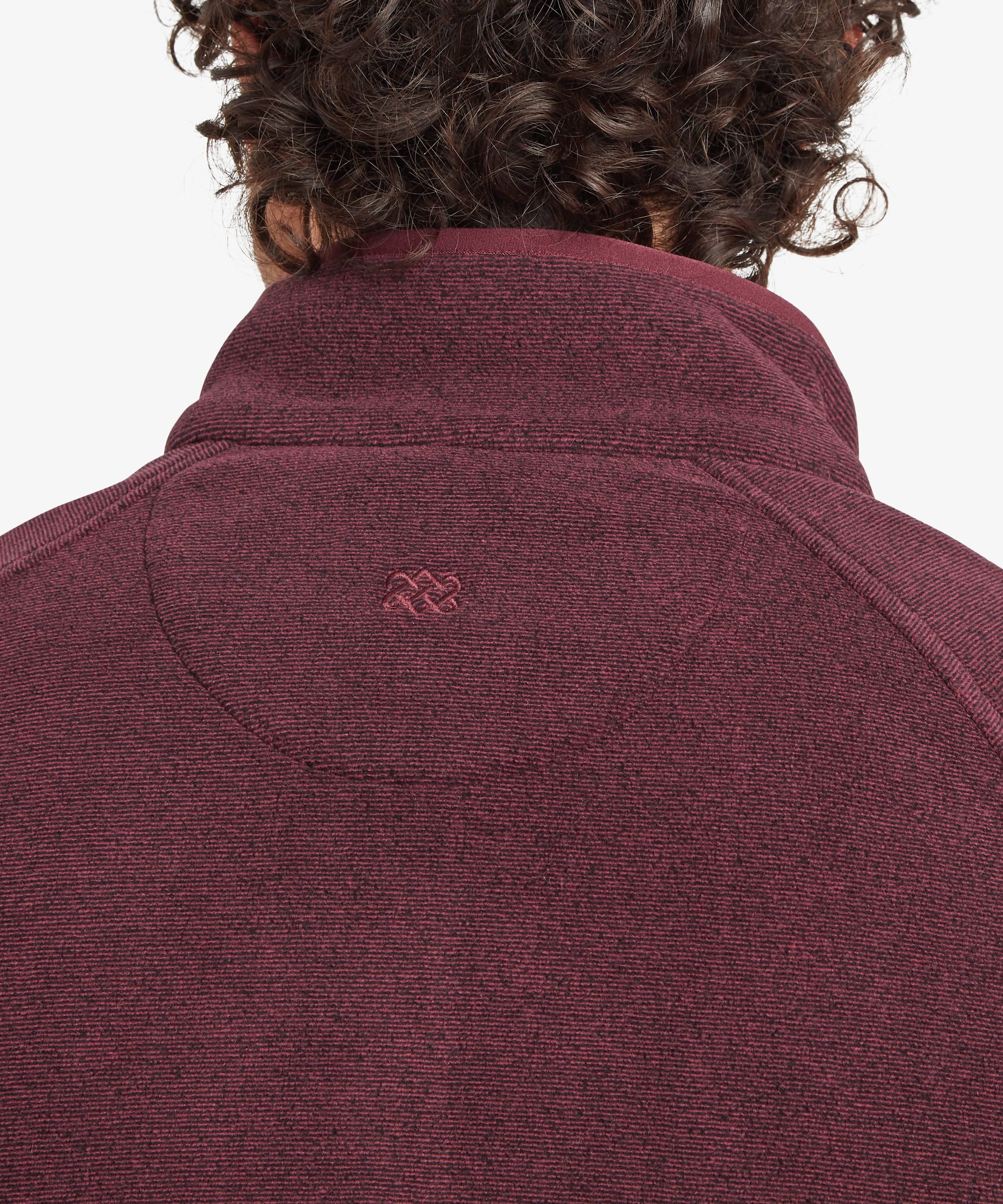Rear close-up of the burgundy fleece jacket collar, highlighting the raised stand collar construction and subtle embroidered logo centered below the neckline.