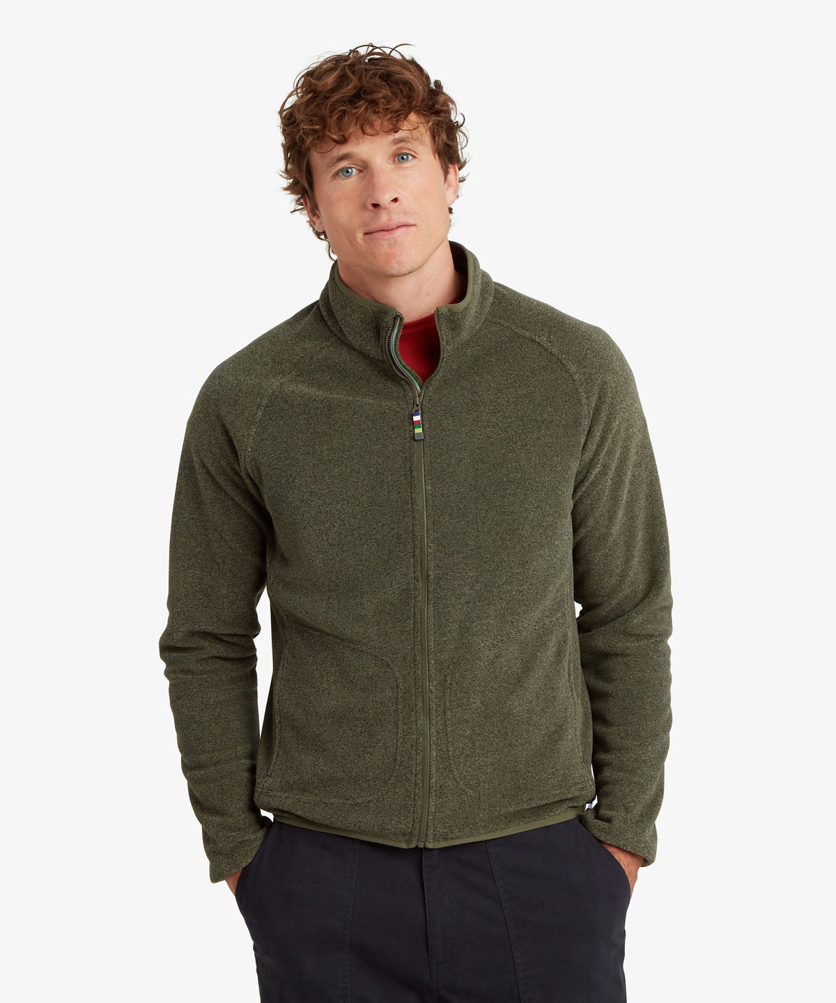 A man wearing an olive green quarter-zip fleece jacket over a red shirt.