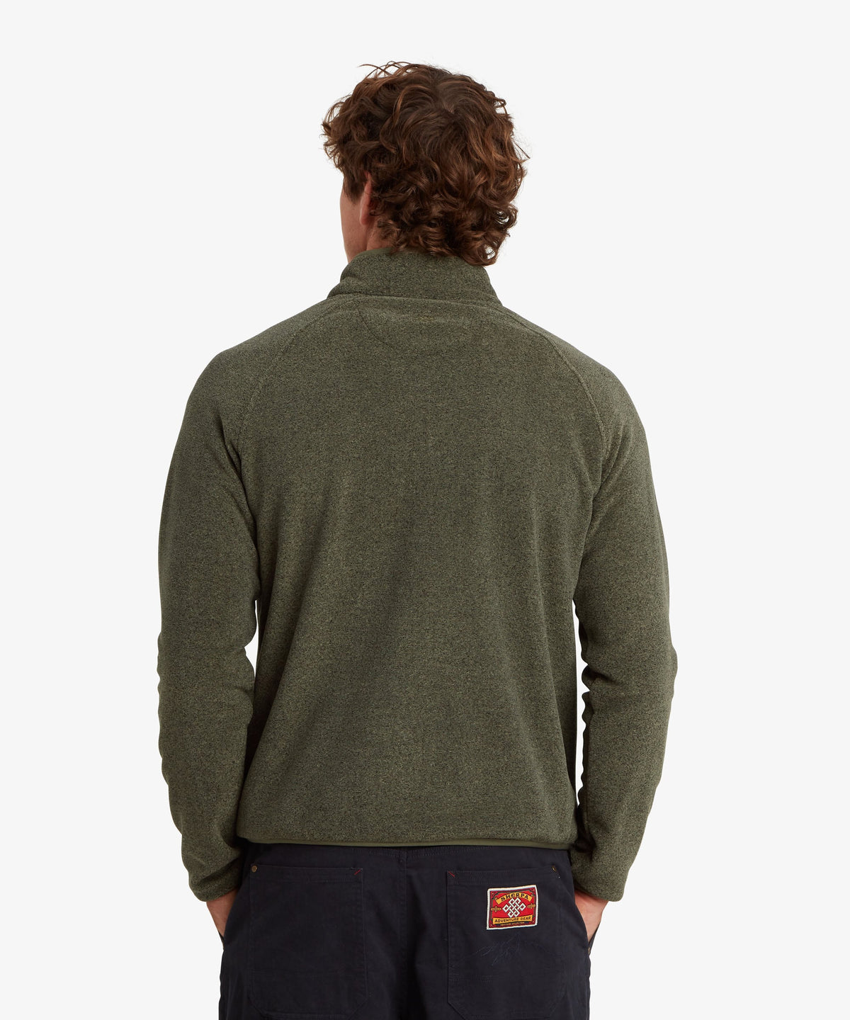 A man viewed from the back wearing an olive green quarter-zip fleece pullover.