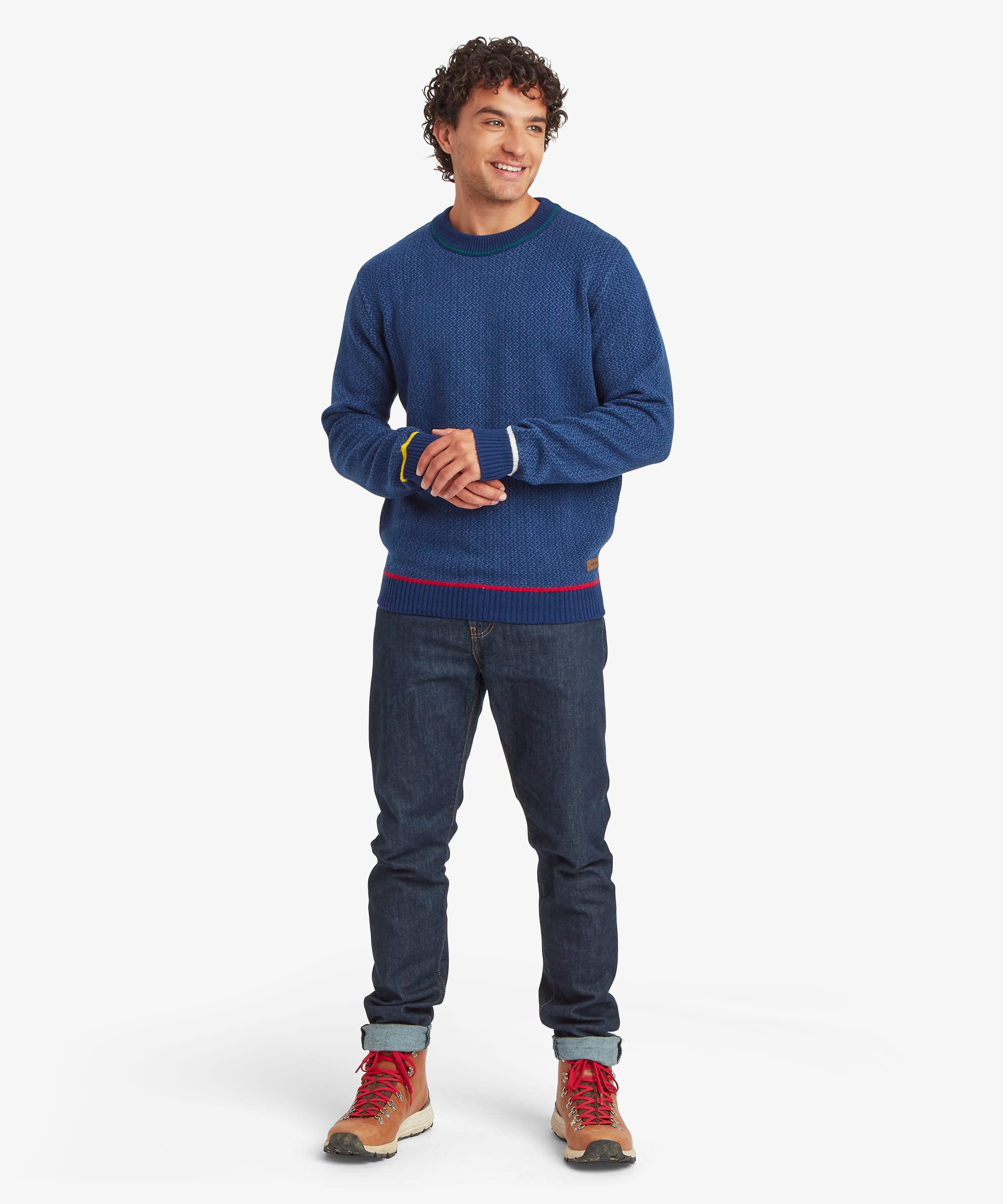 Full-body front view of a model wearing a blue textured knit crew neck sweater with colorful contrast accents at the hem and cuffs.