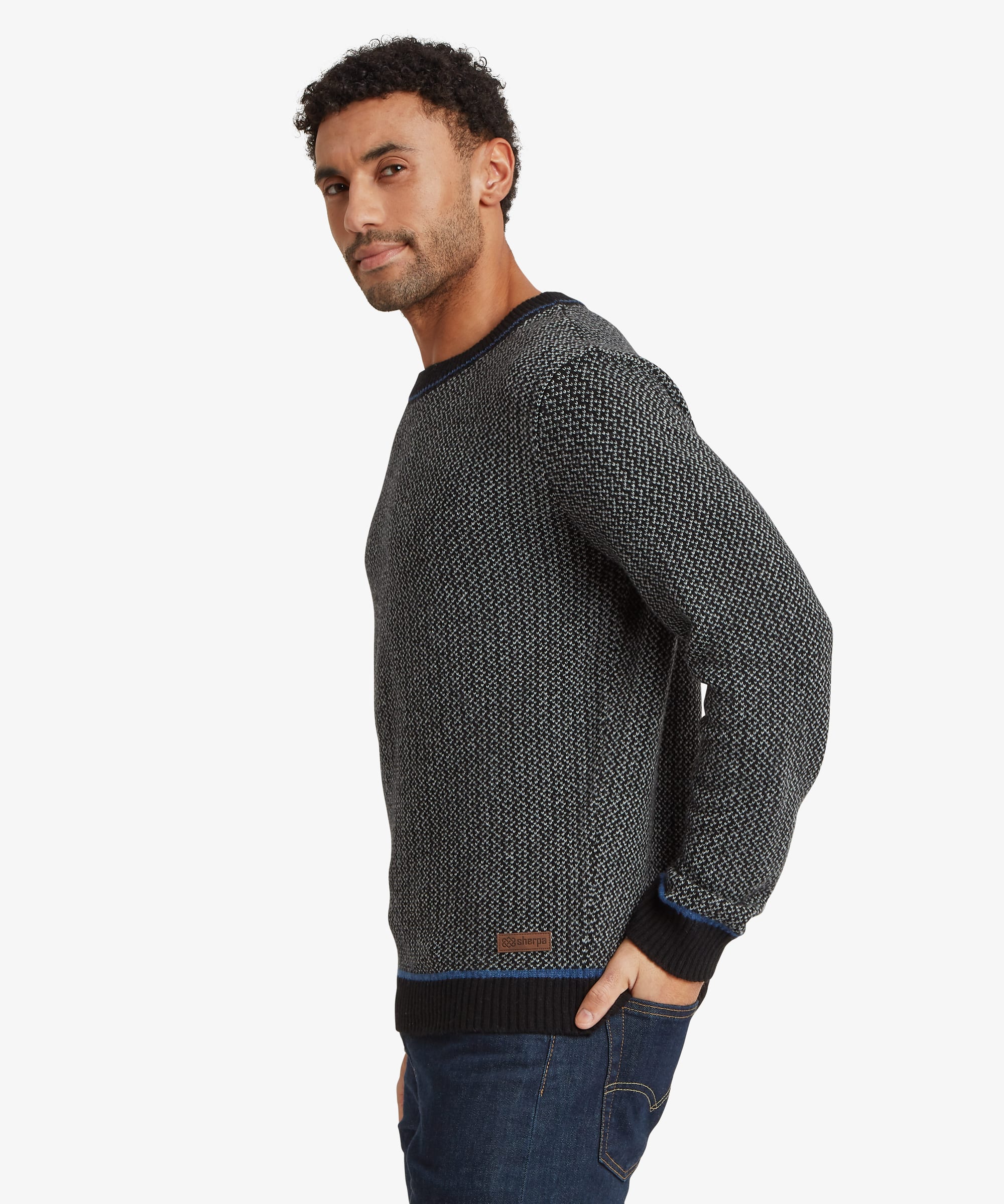 Side profile of a charcoal grey textured knit sweater showcasing the classic crew neckline, long sleeves, and ribbed cuff detailing.