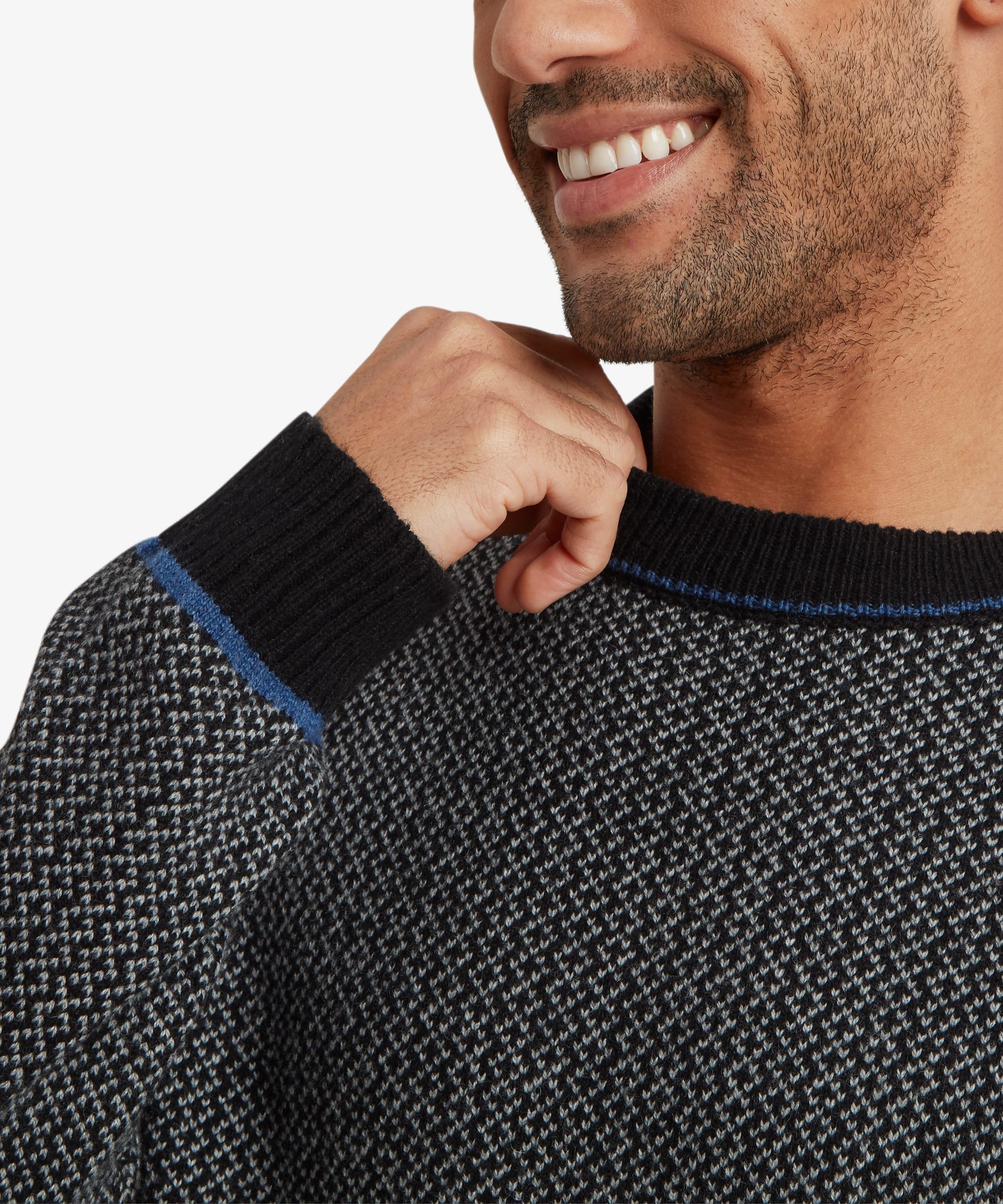 Close-up detail of the grey textured sweater highlighting the intricate knit pattern, ribbed crew neckline with blue contrast trim, and premium knit construction.