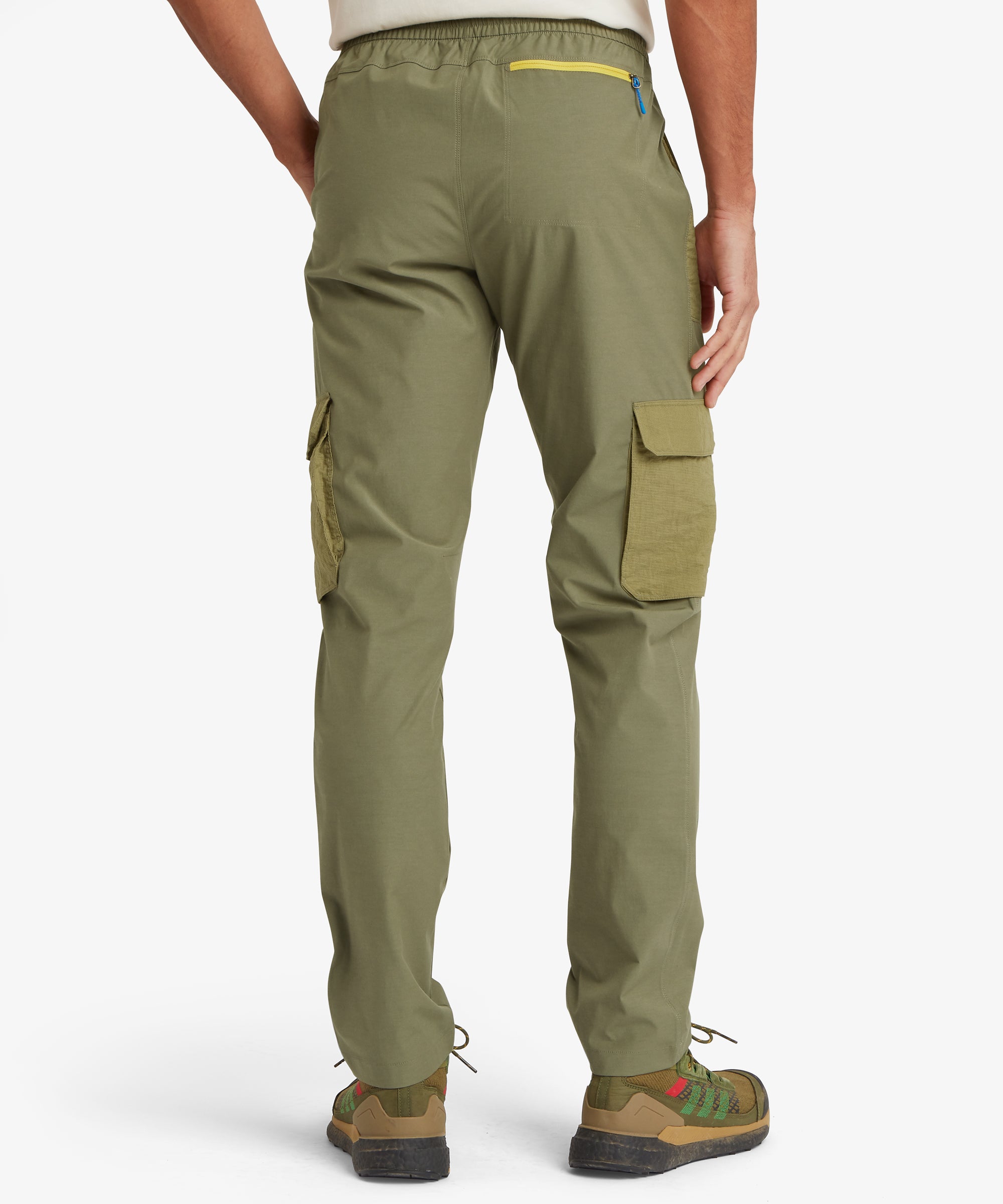 Rear view of green cargo pants with multiple pockets on a white background