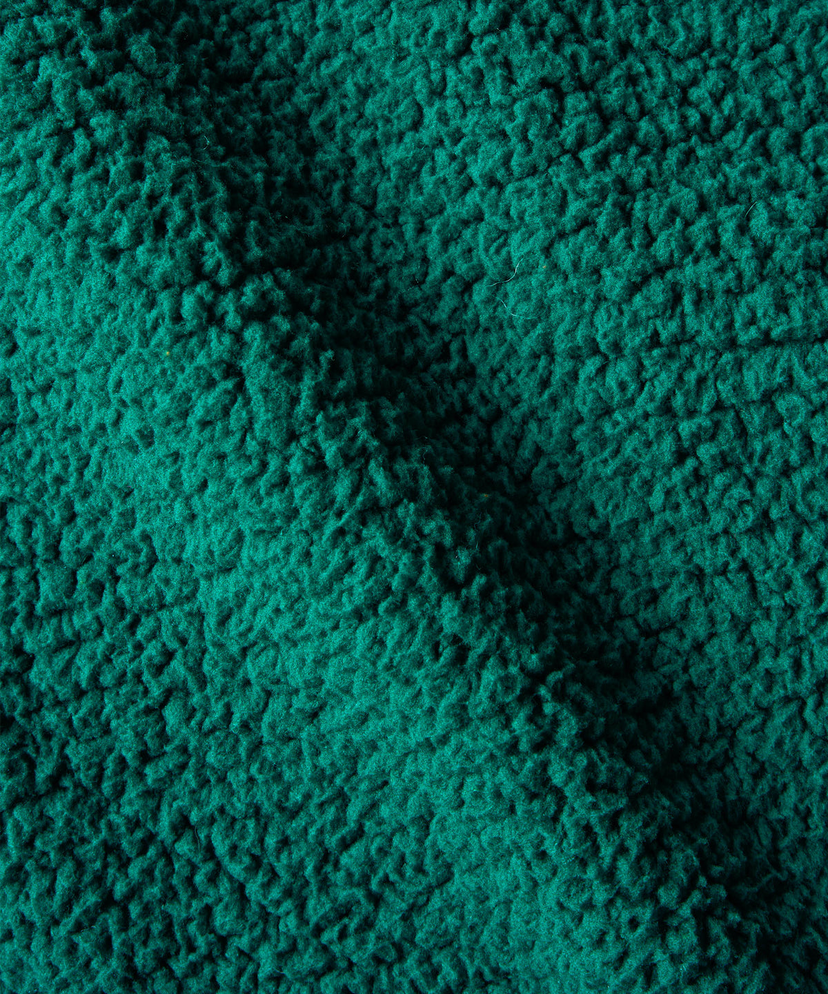 A close-up of a textured, fleece in a teal green color, showing the pile.