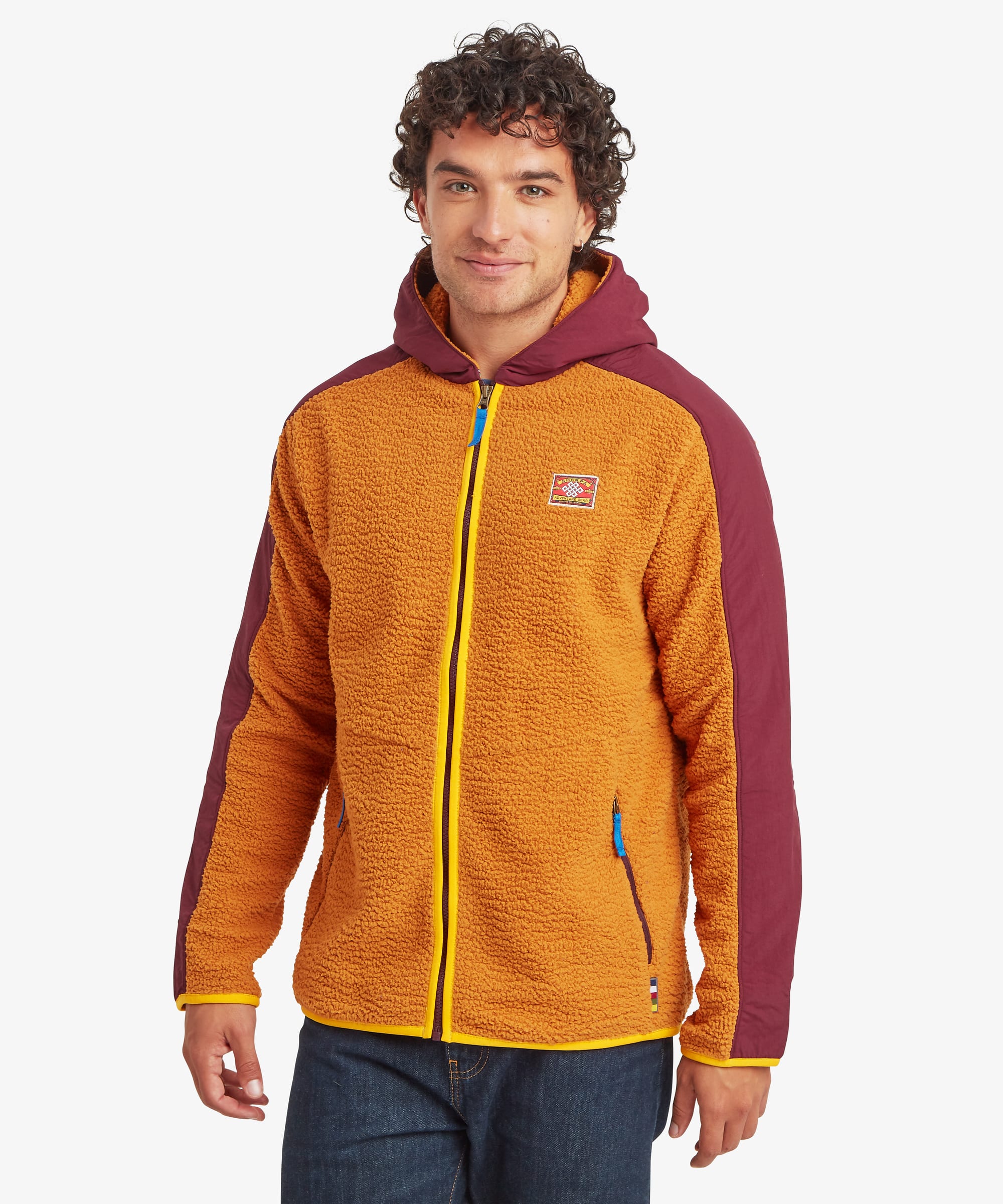 Male model wearing the Sherpa Tarcho Hooded Jacket in yellow, shown from the front, featuring soft high-pile fleece, contrasting burgundy hood and sleeves, yellow contrasting zip binding, full-zip fastening and zipped hand pockets.