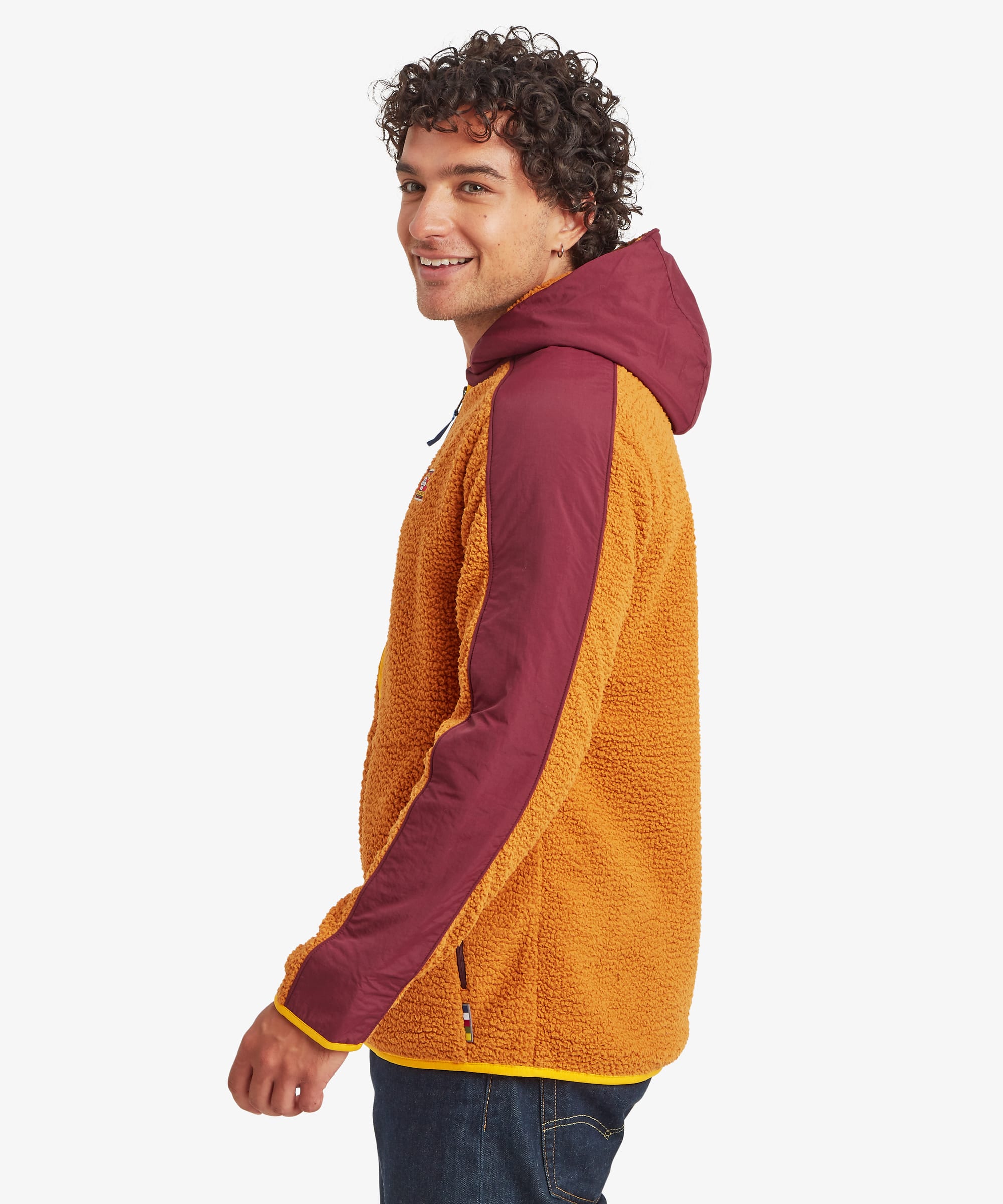 Male model wearing the yellow Sherpa Tarcho Hooded Jacket from a side angle, highlighting the textured fleece fabric, contrasting hood and sleeves, and comfortable fit.