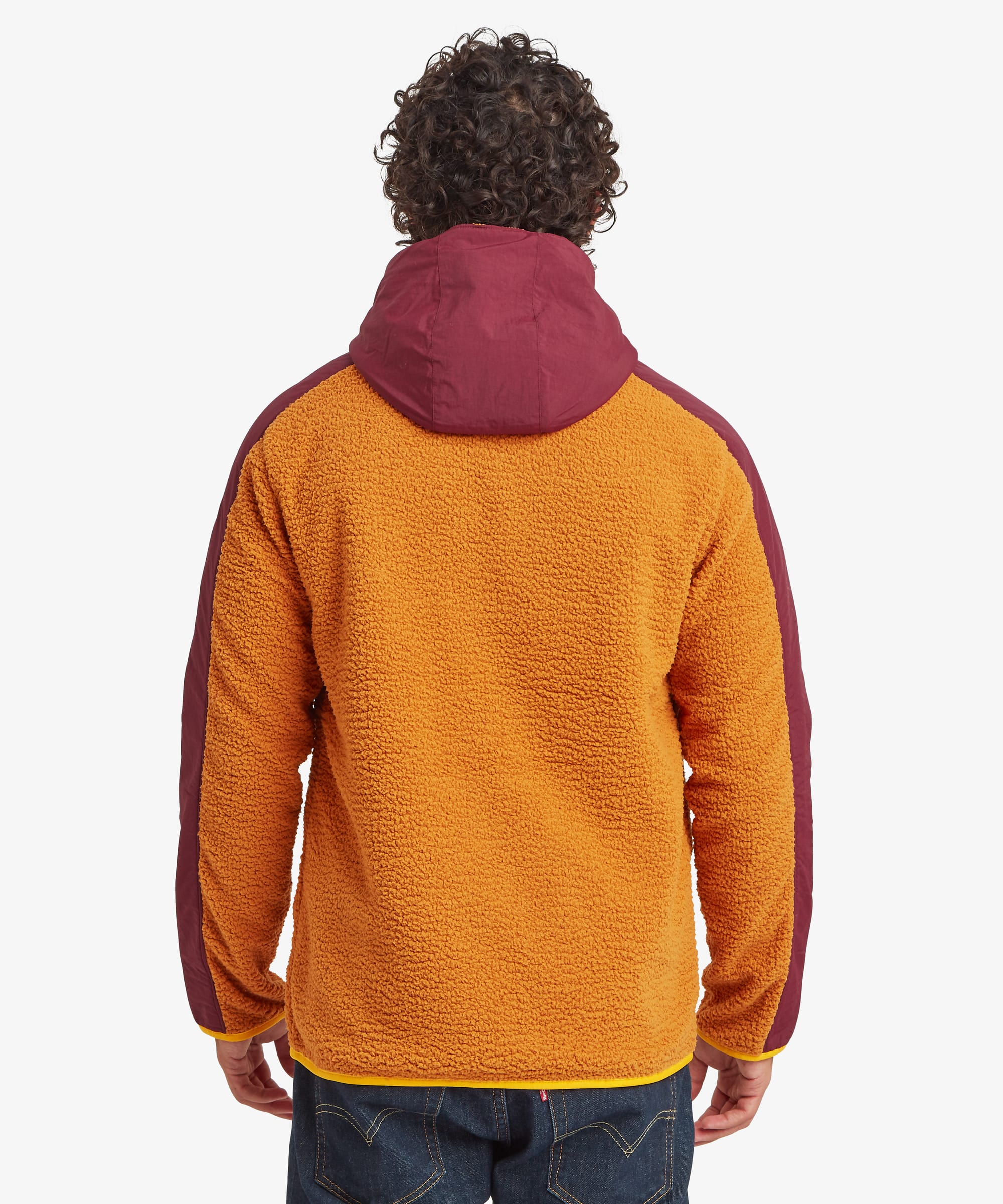 Rear view of a male model wearing the yellow Sherpa Tarcho Hooded Jacket, showing the contrasting burgundy hood, textured fleece back and relaxed silhouette.